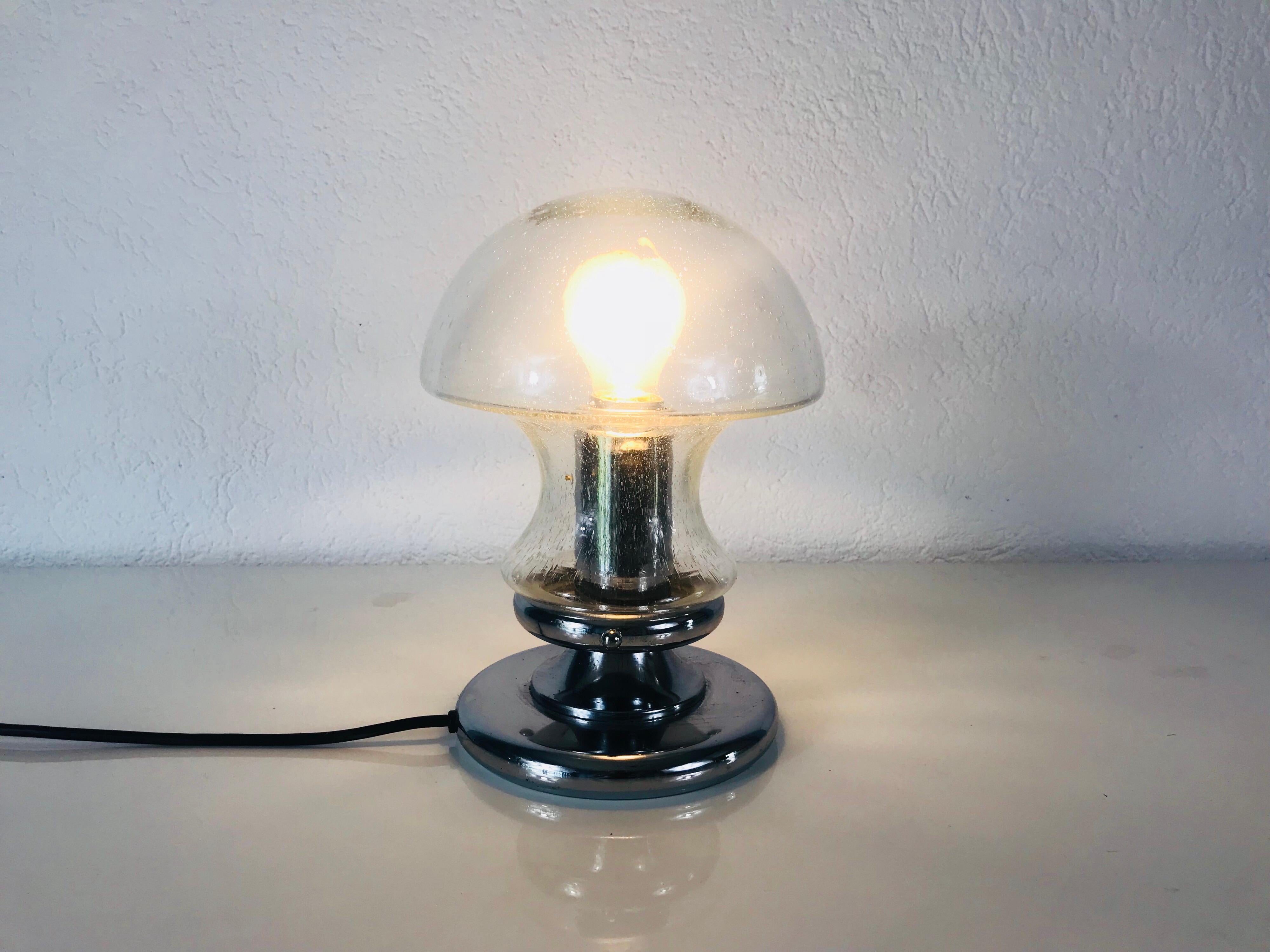 A Doria table lamp made in Germany in the 1970s. It is fascinating with its rare glass shape. The design of the lamps is similar to a mushroom. Murano glass shade with chrome aluminium button.

Measurements:

Height: 28 cm

Diameter: 16