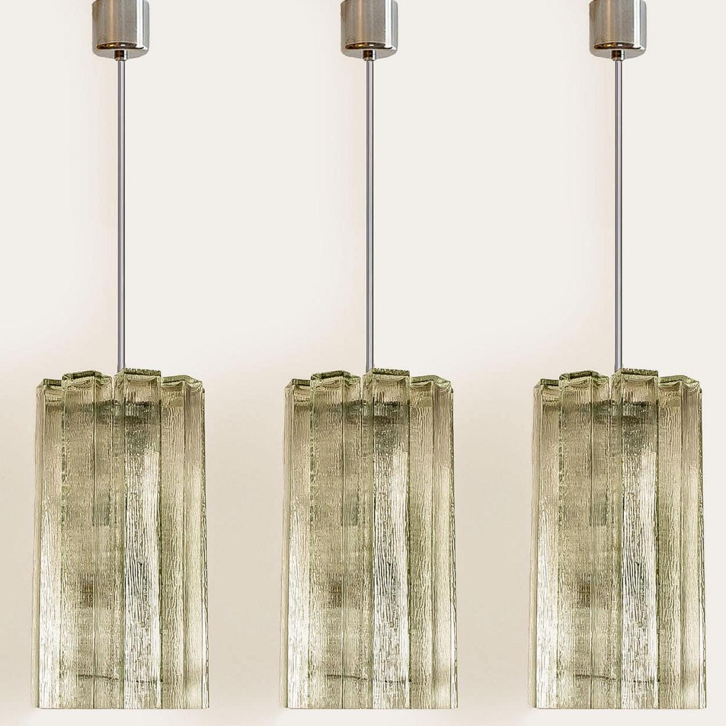 Pendentif moderne du milieu du siècle produit par Doria Leuchten en Allemagne dans les années 1960. La lampe présente un cadre chromé auquel sont suspendus 8 tubes en verre de Murano.

Le lustre est équipé de cinq douilles E27 orientées latéralement