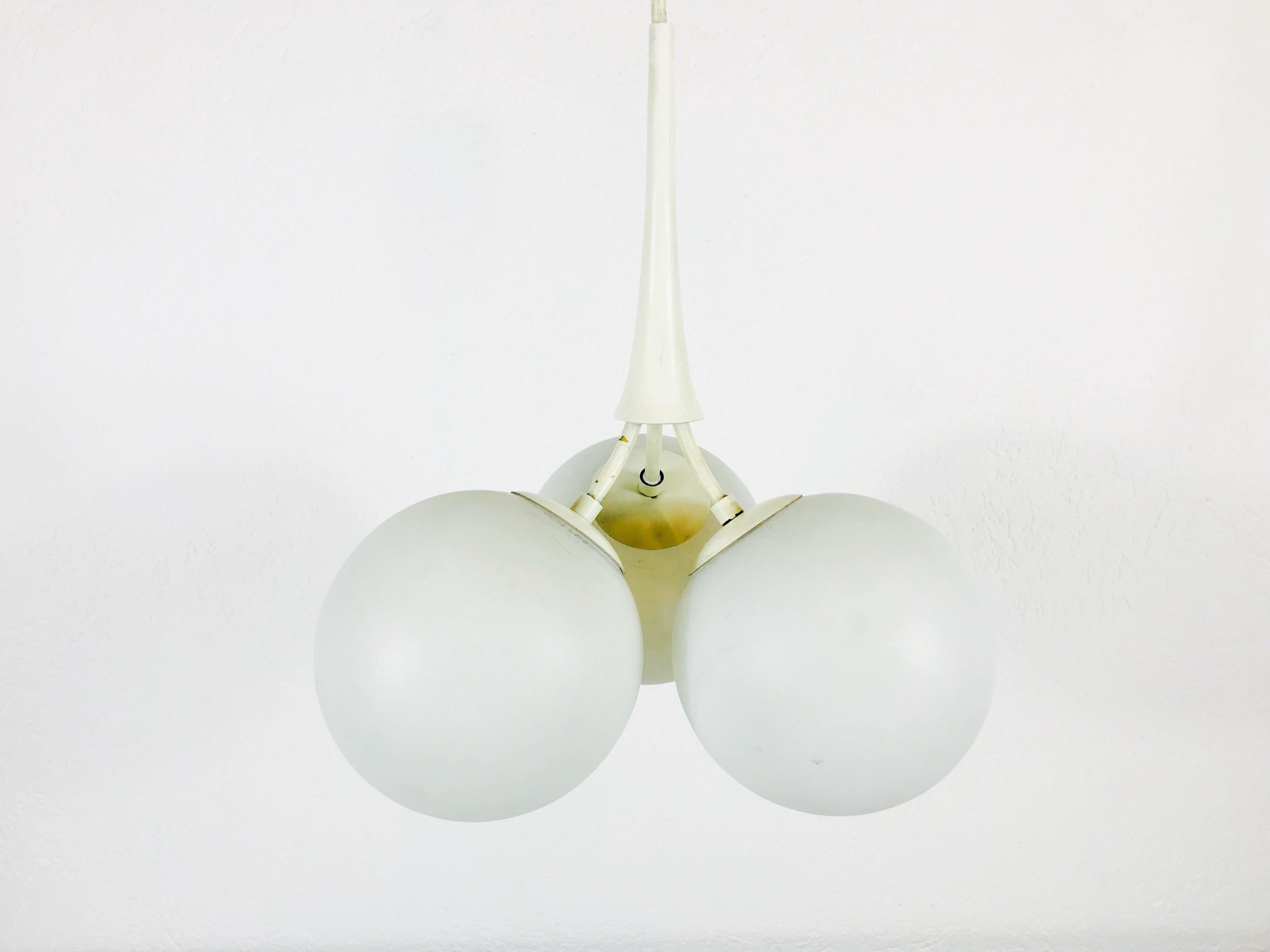 A Space Age design hanging lamp made in Germany in the 1970s. Three opaline glass balls secure to the white metal body. The short arms are also made of metal.

Measurements:

Height: 60 cm

Diameter: 28 cm

The light requires three E14 light
