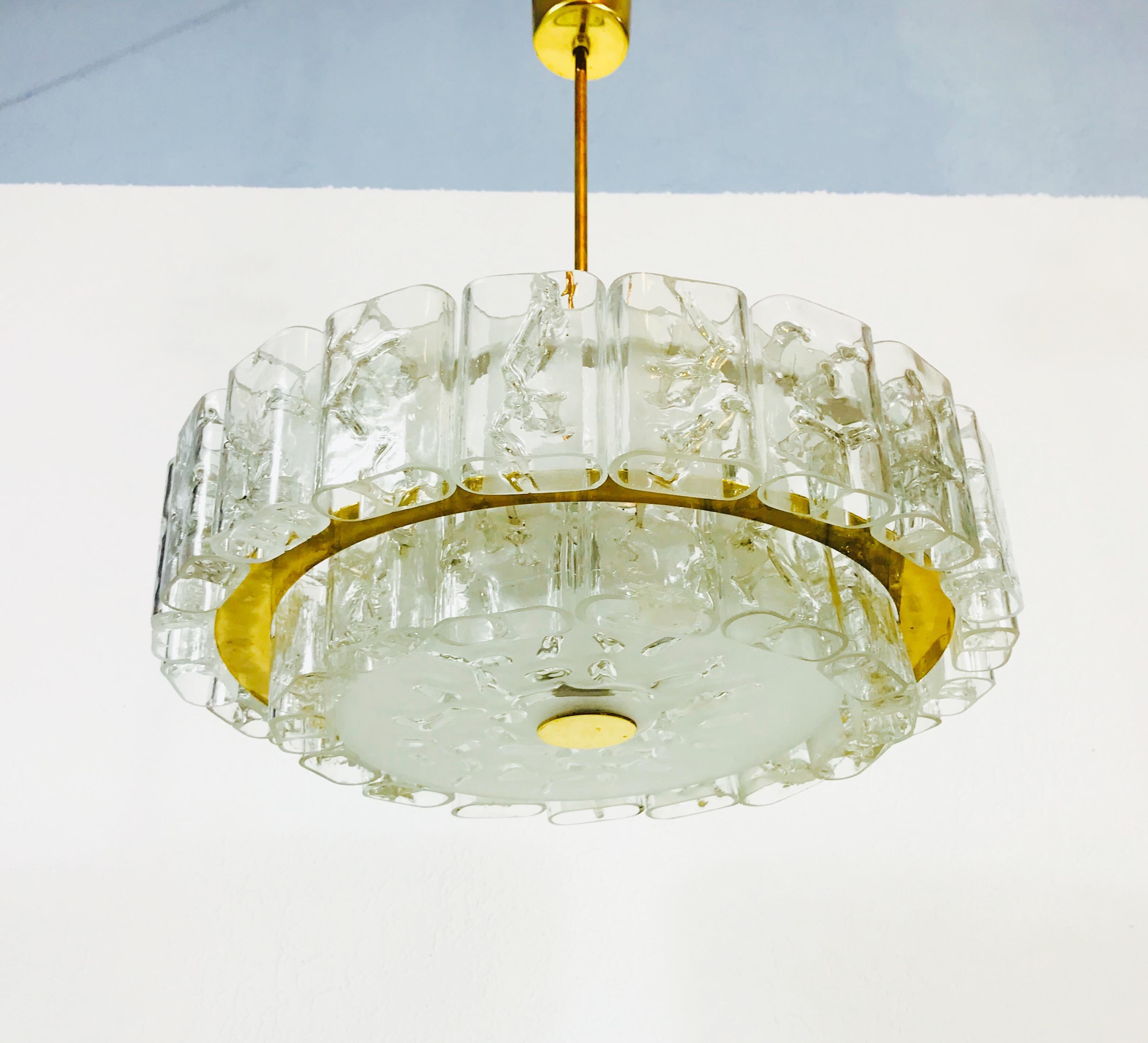 A Doria ice glass chandelier made in Germany in the 1960s. It is fascinating with its rare glass shapes. A bras body with a brass bar. There is a frosted glass diffuser surrounded by a high polished brass disc. 

The fixture requires four E14