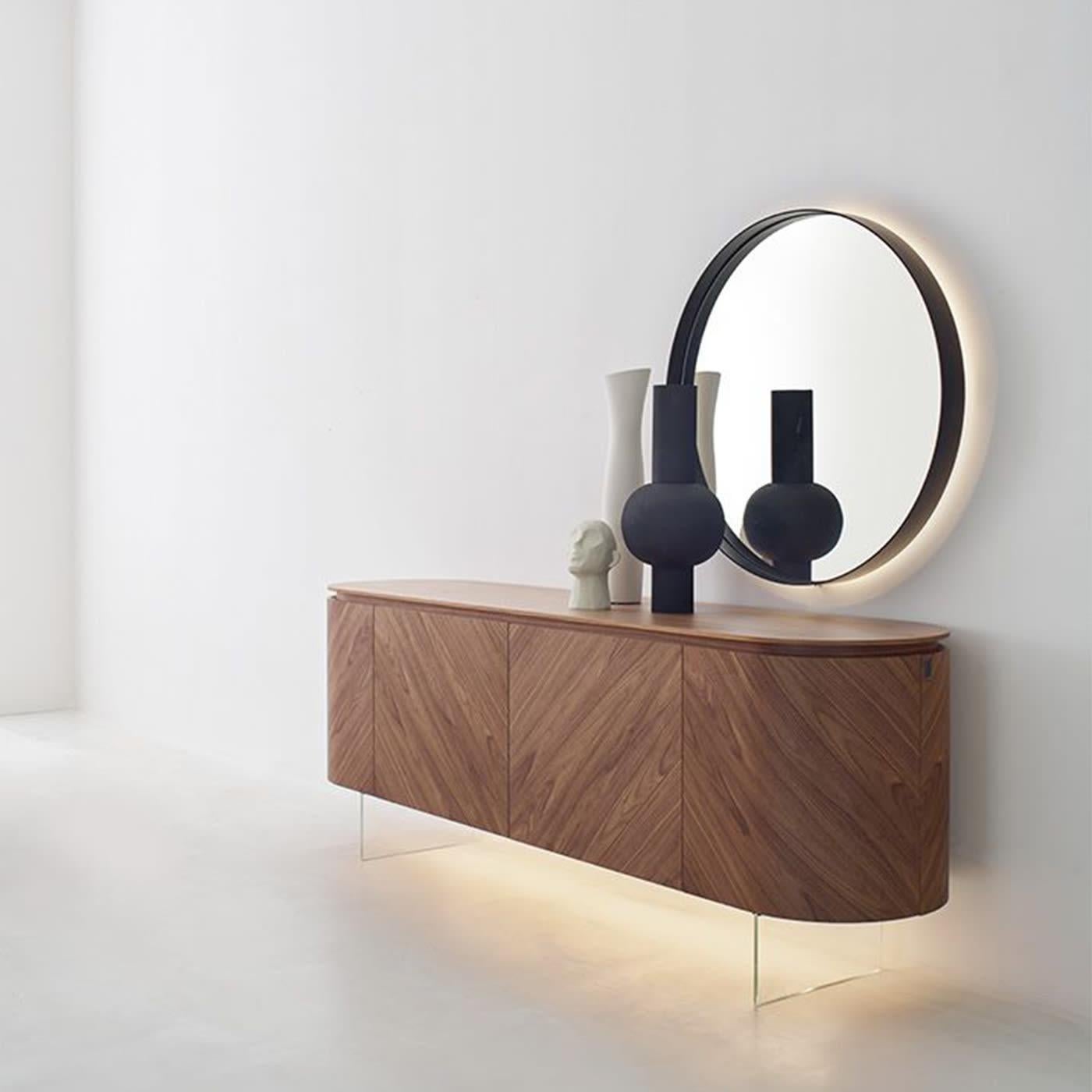 Ein subtiles industrielles Flair durchzieht diesen raffinierten Spiegel, ein hervorragendes Beispiel für minimalistisches Design. Sie ist essentiell in ihrer perfekt runden Form, die die geometrische Perfektion des Kreises zelebriert, und wird von
