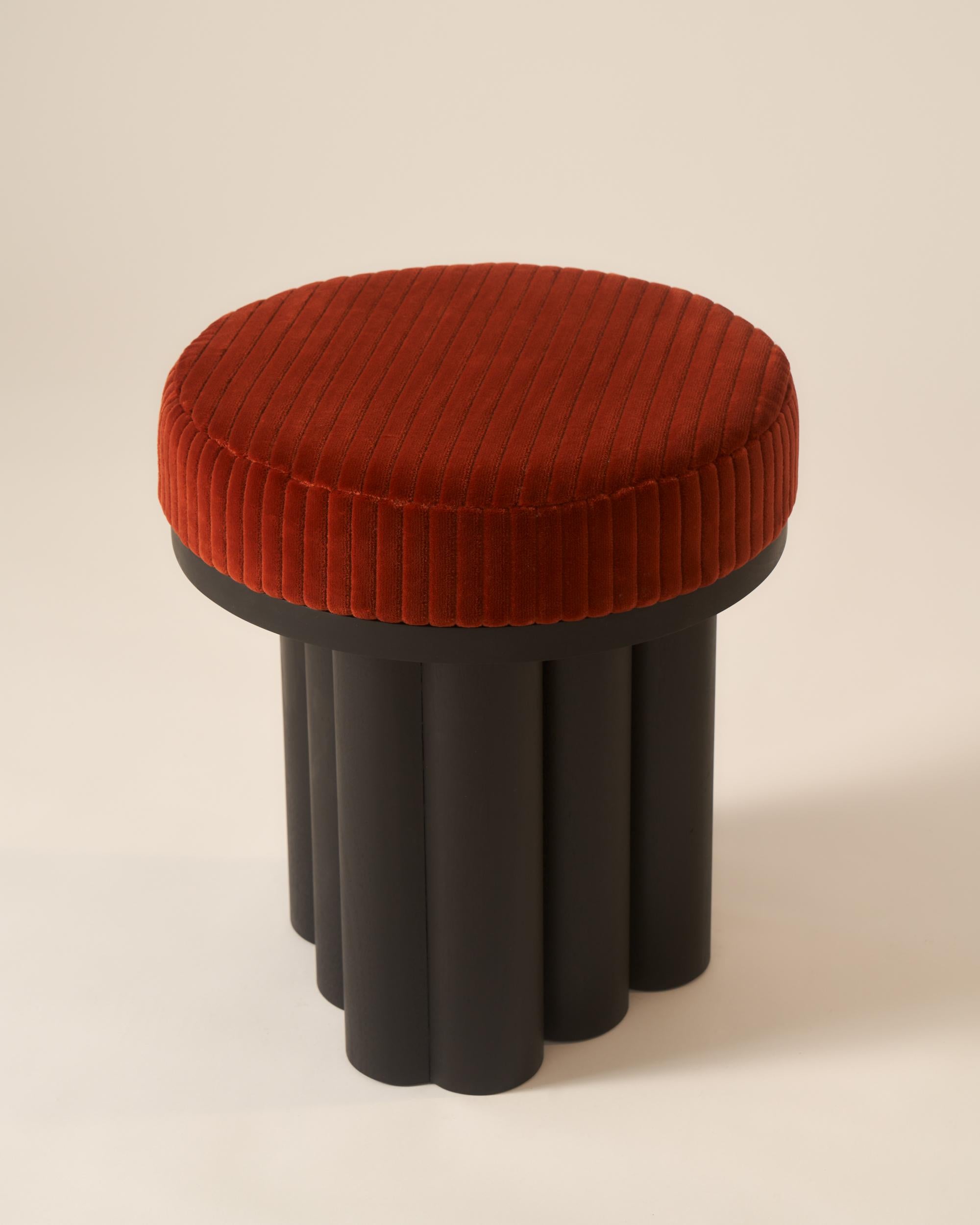 A compact, sculptural seat that takes cues from classical architecture. The Doric Stool features bold, columnar legs and a generously upholstered top, offering comfort and presence in a small footprint. Perfect as occasional seating or paired with a
