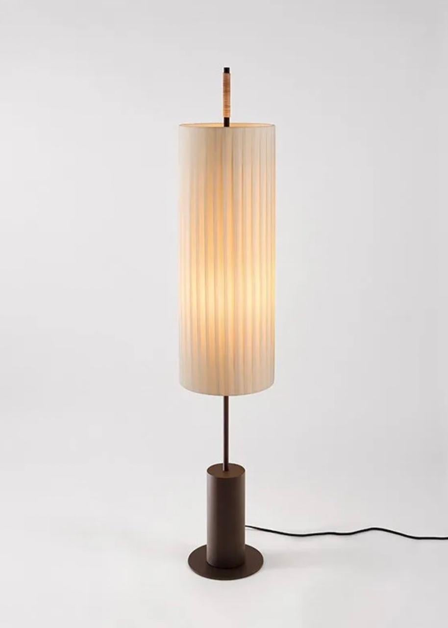 The balance of materials that make up this lamp—its cotton shade, metallic structure and stitched leather grip—are a vindication of industrial craftsmanship. With a strong presence, Dórica is an impressive lamp that evokes the classical doric