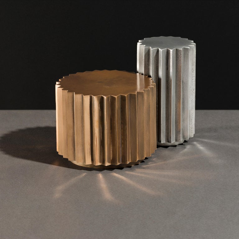 Side tables in cast bronze or aluminum of different diameters and heights that can be combined to create a coffee table. Inspired by Doric columns in Archaic architecture, the extruded multi-point stars have a different finish on each vertical face: