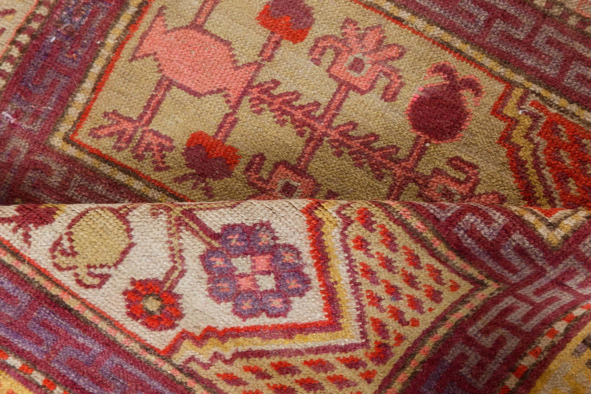 Tapis en laine Khotan 'Samarkand' du milieu du 20e siècle, fait à la main, dans les tons violet, rouge et jaune.
Taille : 4'11