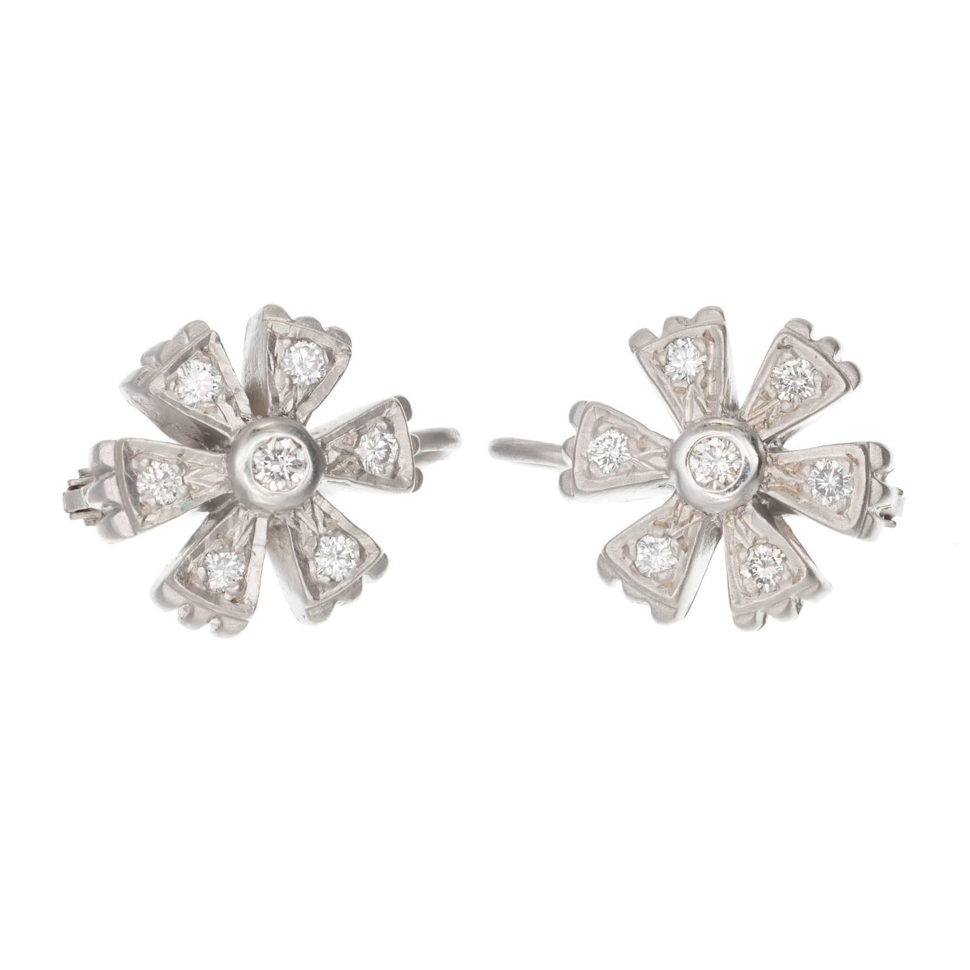 Doris Panos Diamond 18k white gold dull finish dangle flower earrings.

14 round full cut diamonds, approx. total weight .30cts, G, VS
18k White Gold
8.1 grams
Tested and stamped: 18k
Hallmark: DP 2000
Depth: 5.48mm
Top to bottom: 17.11mm or .67