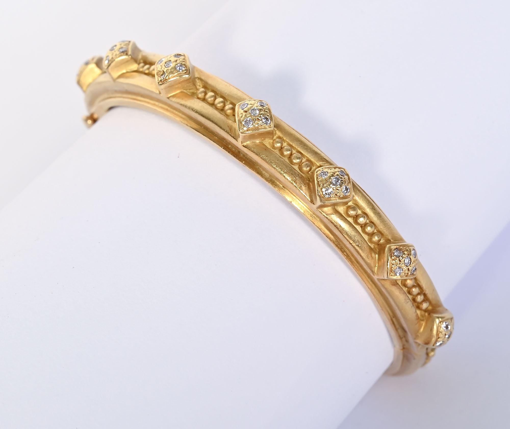 Gold and diamond bangle bracelet by Doris Panos. The bracelet has seven stations of diamonds weighing a total of 35 points. Between the diamond shaped stations and throughout the back are tiny gold balls. The hinged bracelet is 2 3/16 in interior