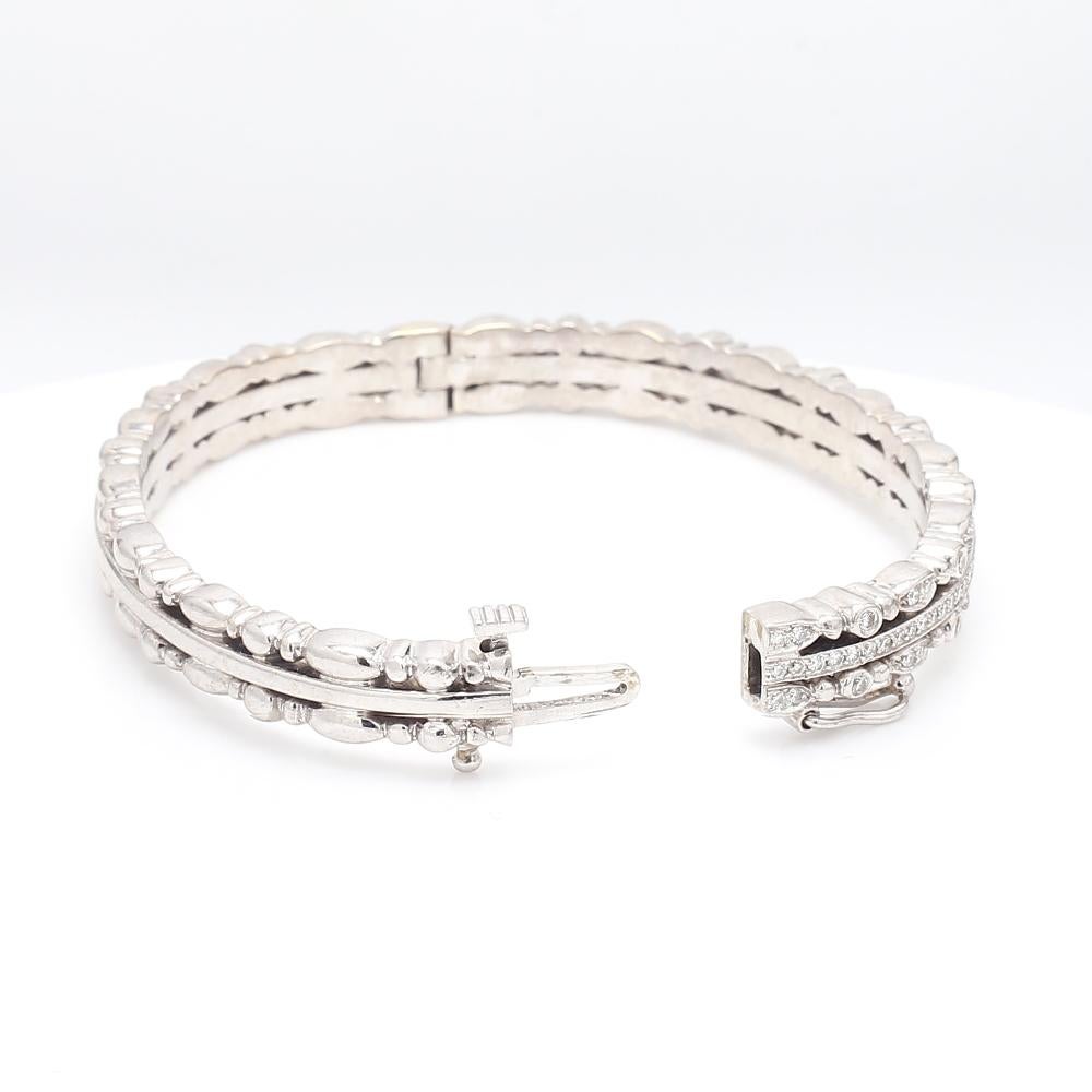 Doris Panos, 18K white gold, bangle style bracelet. Bracelet is set with one hundred four (104 ) round brilliant cut diamonds (approx. 1.50ctw). Box clasp, safety latch, and hinge are in working condition. Ring weighs 54.9 grams and measures