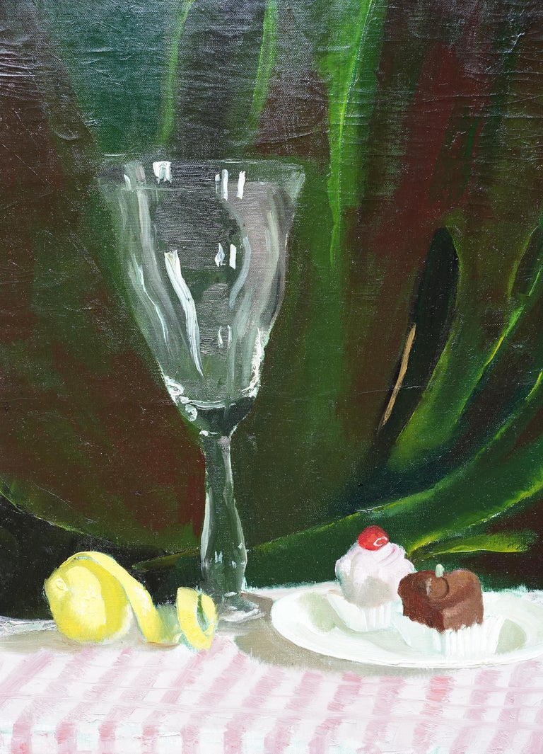 This vibrant still life oil painting is by Scottish artist Doris Zinkeisen. Painted circa 1950 the composition is a glass, lemon and two fondant fancies. They stand on a pink and white stripped table cloth and are the backdrop is a vibrant green