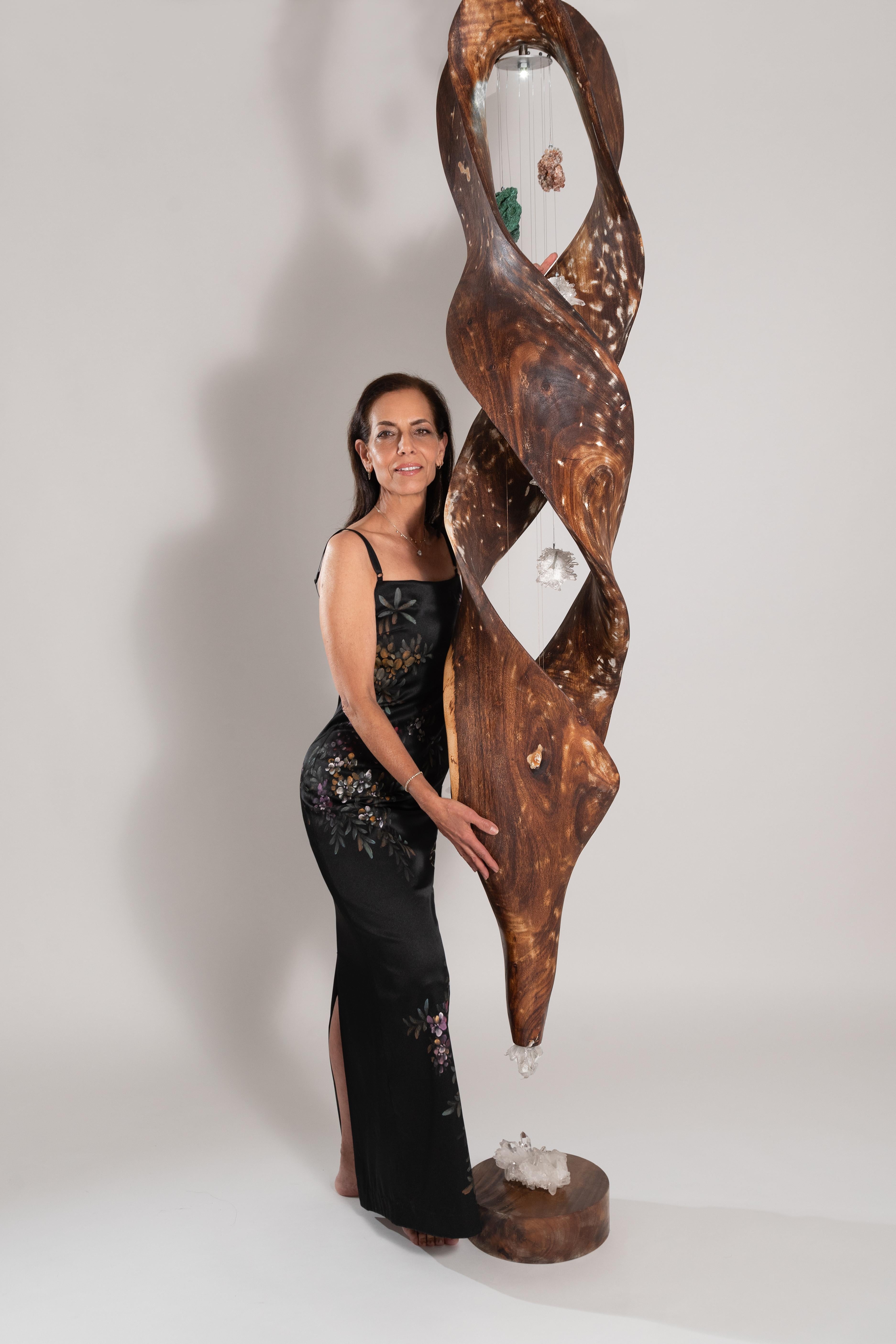 Esta moderna escultura orgánica presenta Raíz de Teca, conocida por sus cualidades estabilizadoras y de enraizamiento, combinada con las poderosas energías curativas de la Malaquita y el Cristal de Cuarzo. Las texturas naturales y los ricos colores