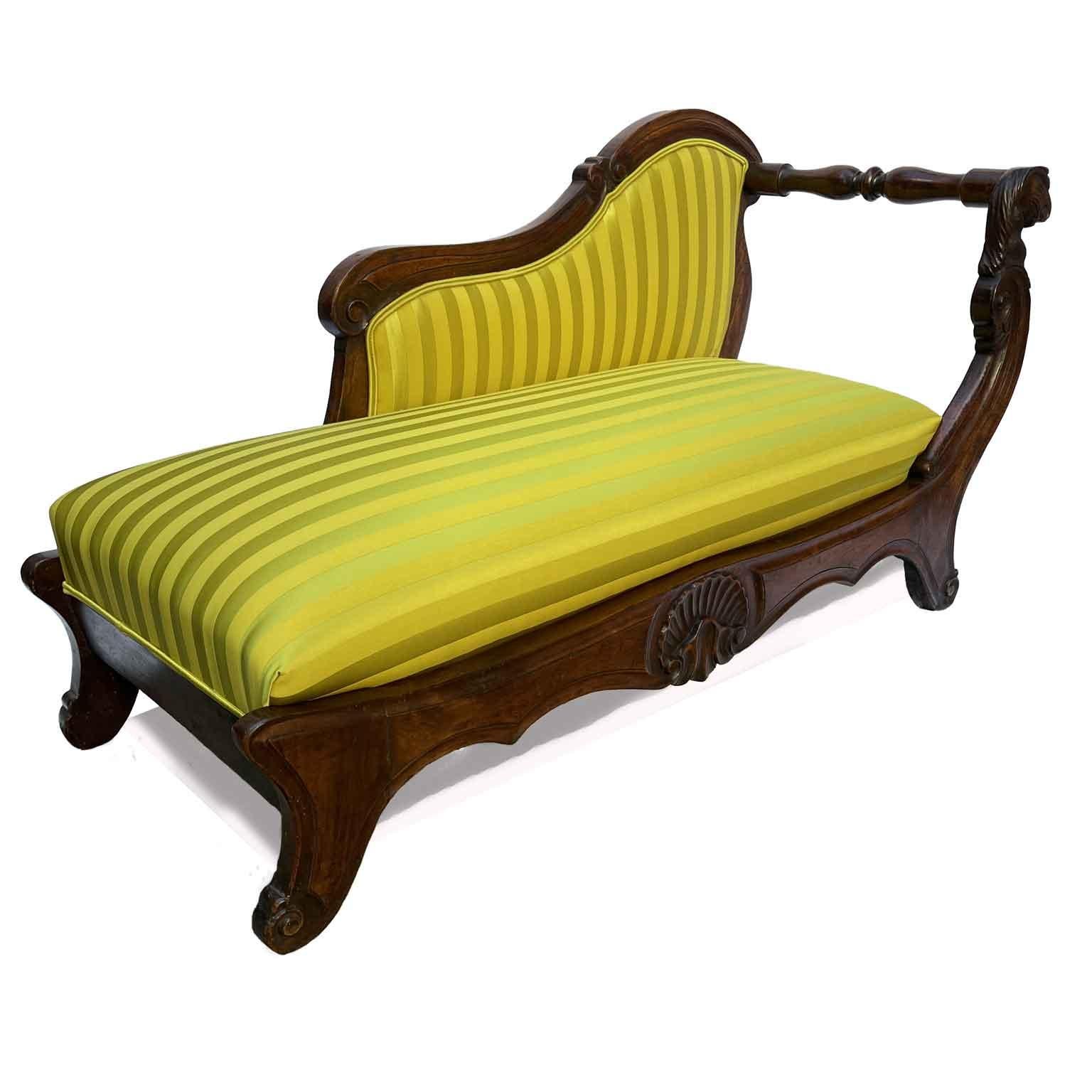 Walnut Dormeuse Mid-1800s with an unusual shape in that it lacks a side back in place of which we find a turned wooden crosspiece. The settee has a solid walnut frame with a beautiful patina; the front is centered by a carved shell,  while the front