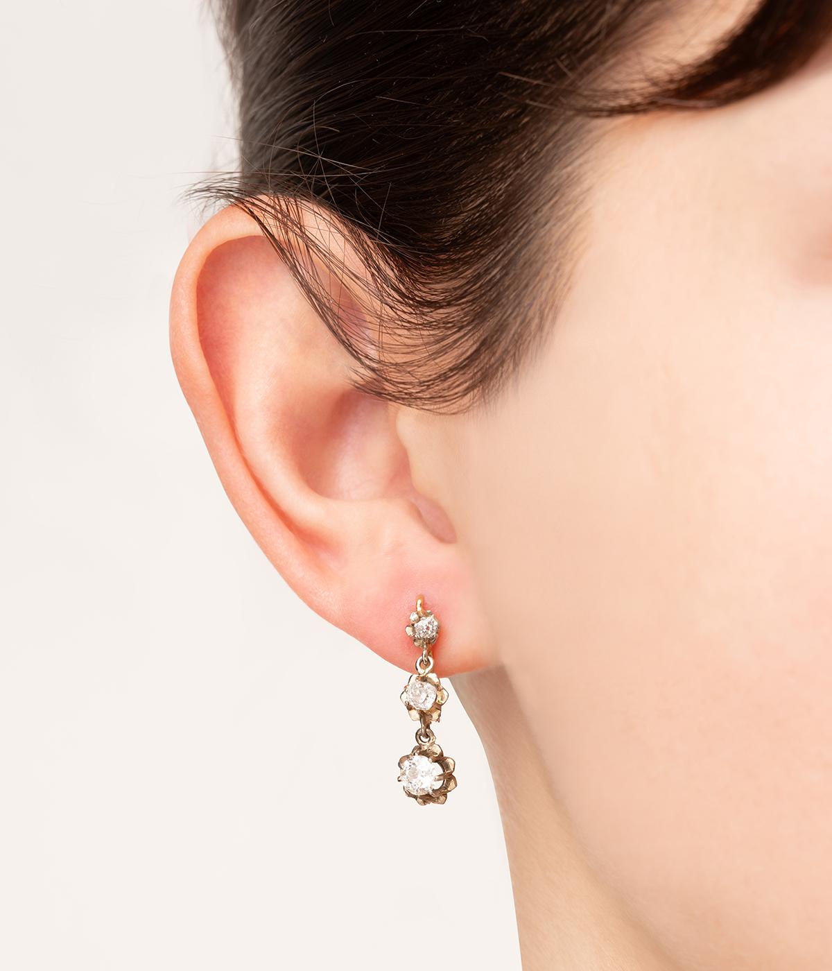Dormeuses anciennes en or 18 carats (750 millièmes) du début du 20ème siècle, ornées chacune d'une ligne de 3 diamants taille coussin ancienne en chute totalisant 1,3 carats.

Poids total du bijou :  2,59 g ambiente.
Hauteur 2 cm.
Poinçon tête