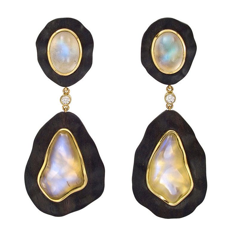 Moonstone and ebony "Bubble" pendant earclips, the moonstones bezel-set in gold and inlaid in carved ebony, with bezel-set round diamond accents at center, the four moonstones weighing 39.97 total carats and two diamonds weighing 0.14