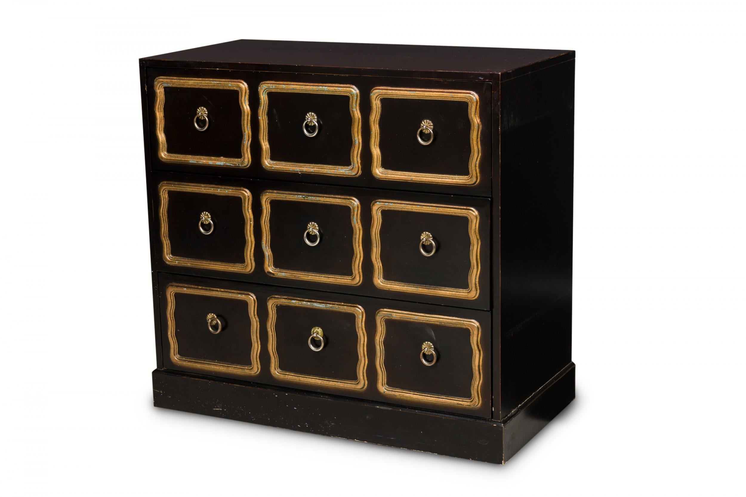 American midcentury chest of drawers painted in black, with 3-drawers with raised gold painted decorative molding on the drawer fronts surrounding three brass ring drawer pulls per drawer. (Dorothy Draper).