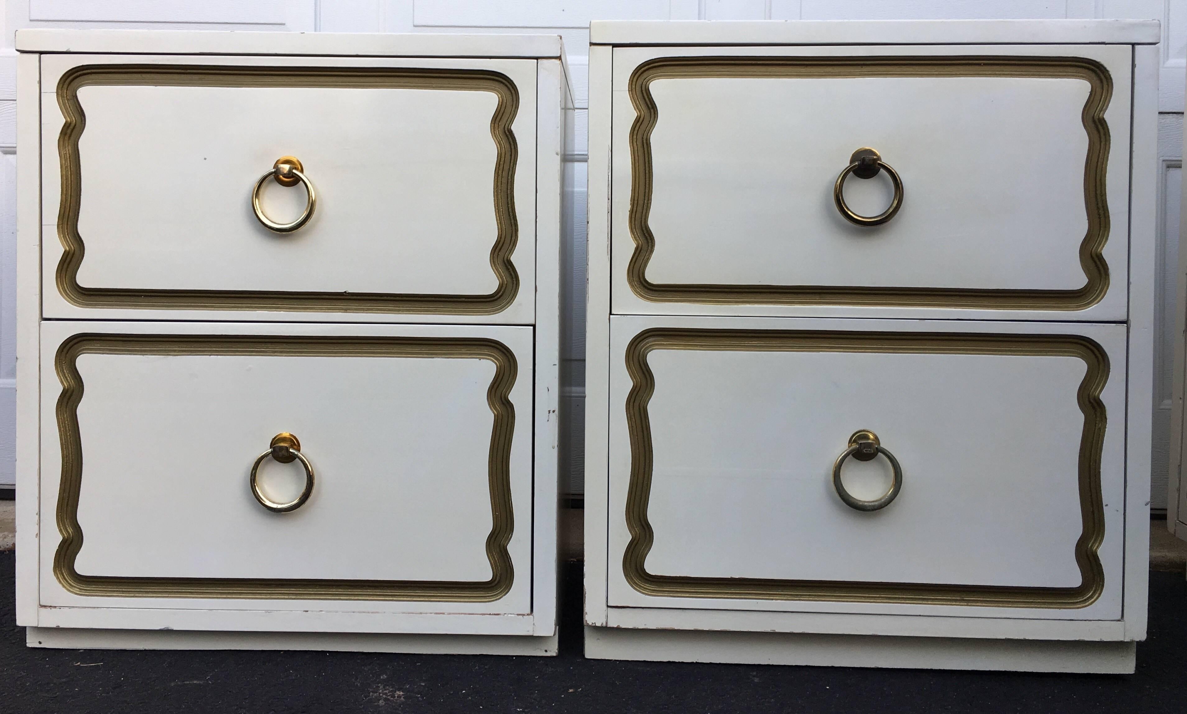 Rare pair of Mid-Century Modern Dorothy Draper Espana for Henredon Heritage style bedside tables. These Hollywood Regency two-drawer nightstands feature original white/cream lacquer finish with carved gold leaf detailing and brass ring