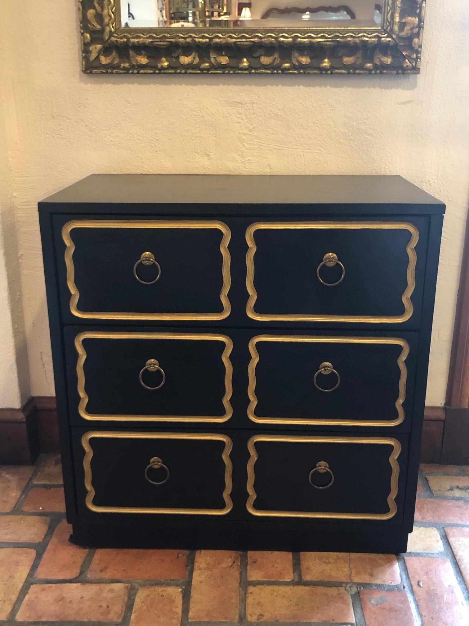 Dorothy Draper espana chest with three drawers. Classic black and gold timeless design. Original circular brass pulls. Fabulous black and gold drawer liner as well.