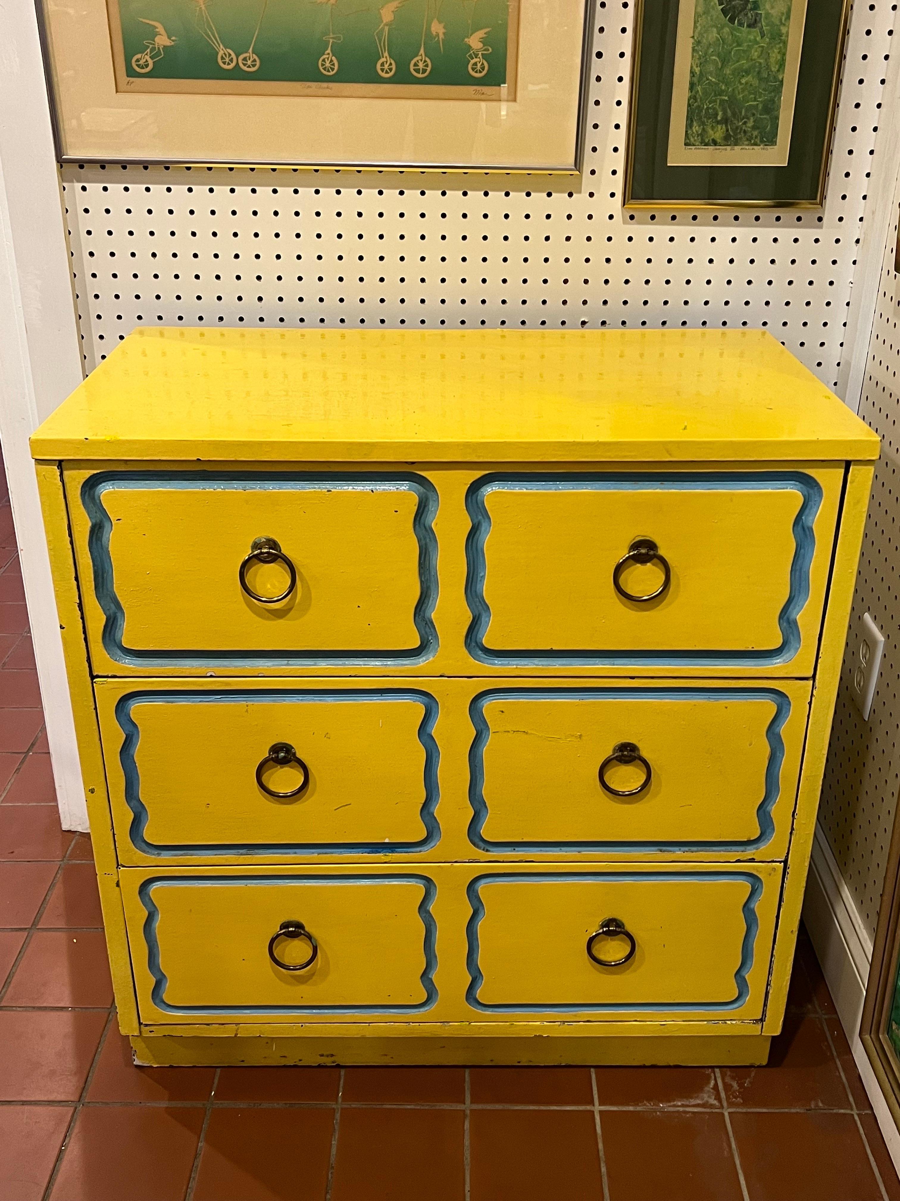 Dorothy Draper Espana chest in yellow. Rare Yellow color with light blue accent. Classic three drawer chest with traditional ring pulls. Drawers lined in gold pleather. This chests painted finish is not a professional refined finish. It would look