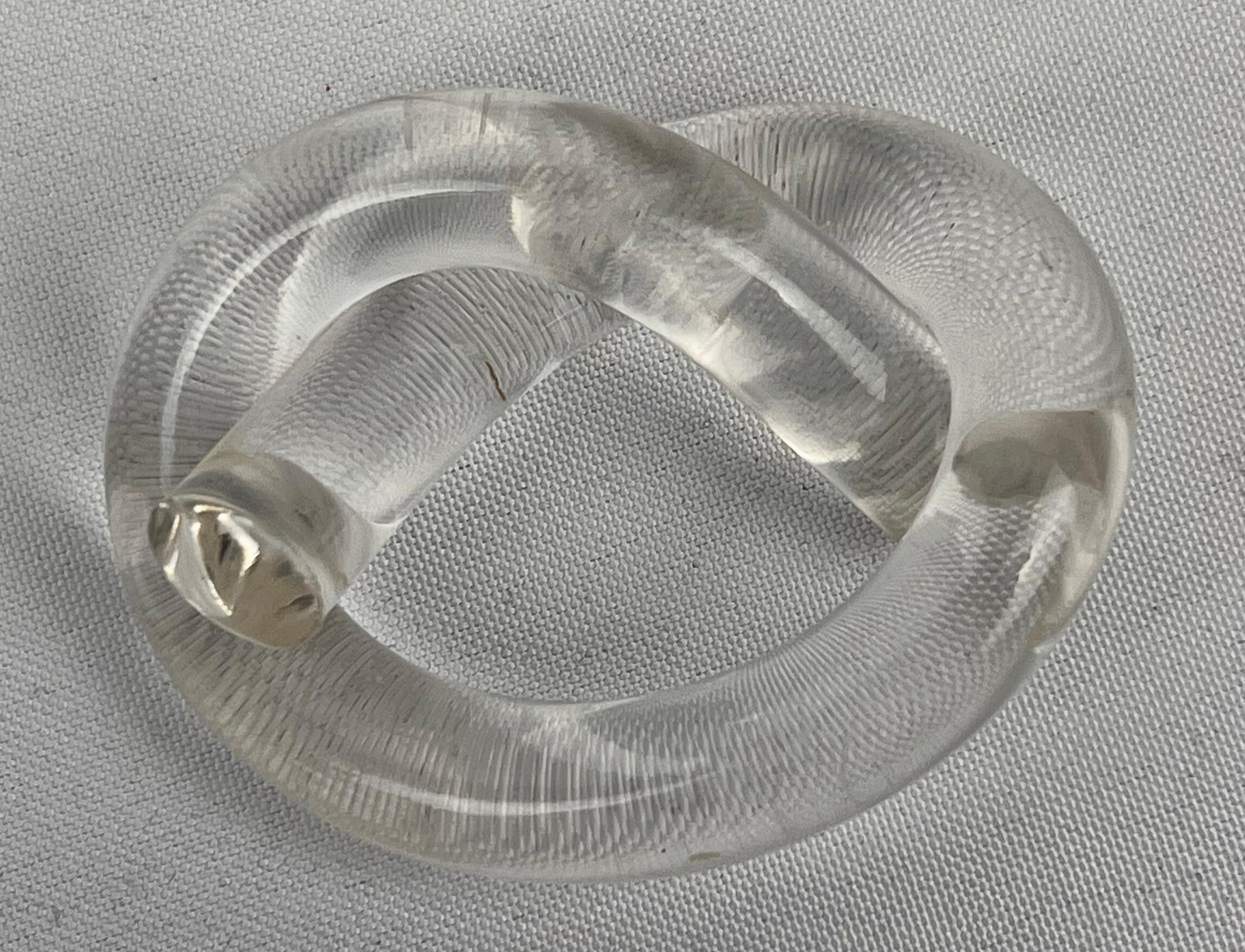 Set of eight Mid-Century Modern clear lucite napkin rings designed by Dorothy Thorpe. Tne material is cylindrical clear ucite twisted to form a whimsical pretzel shape. They are in very good original condition with some very light scratches which is