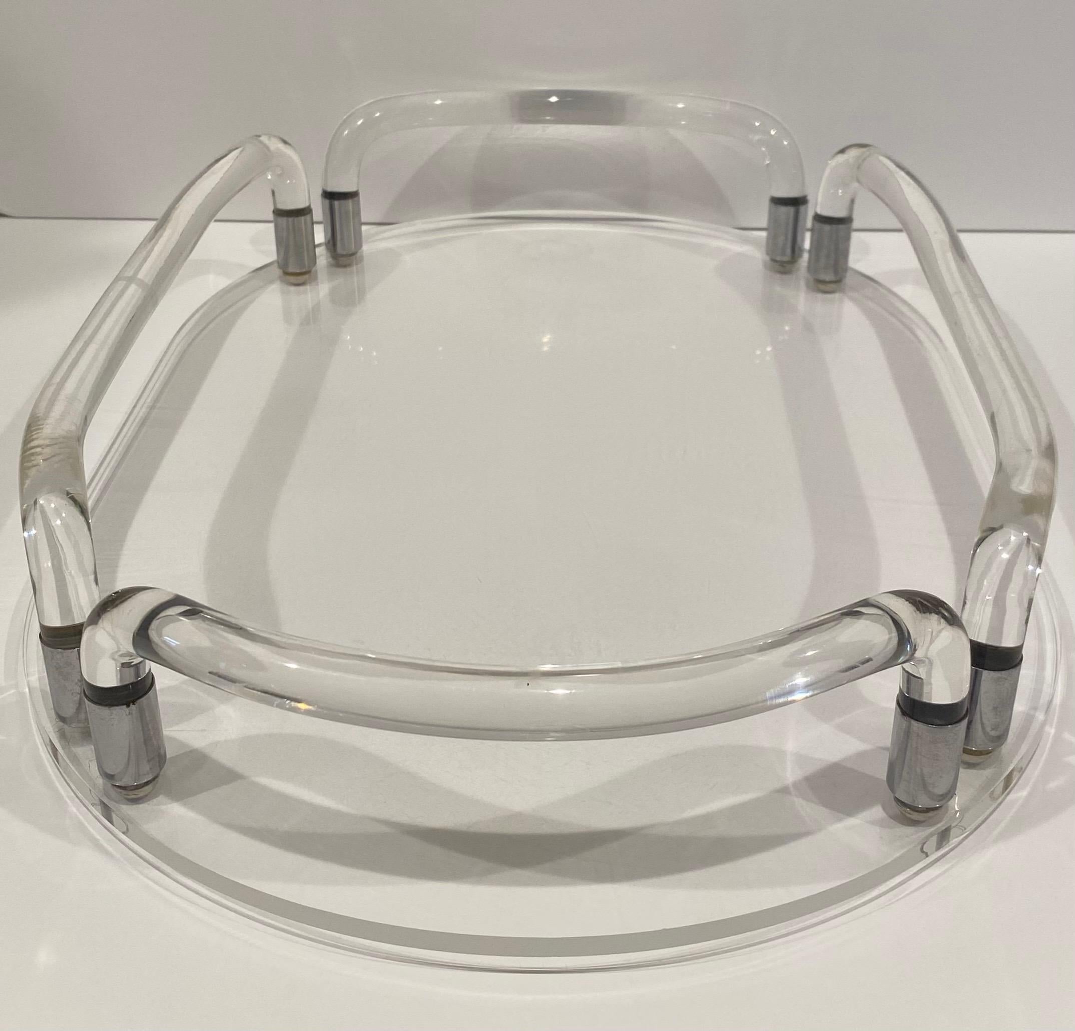 1970's sculptural tubular Lucite handled tray with clear acrylic oval shaped base.  This Mid-Century Modern design features chrome fittings and feet.  The perfect piece for your bathroom vanity or bar service.  Designed by Dorothy Thorpe for