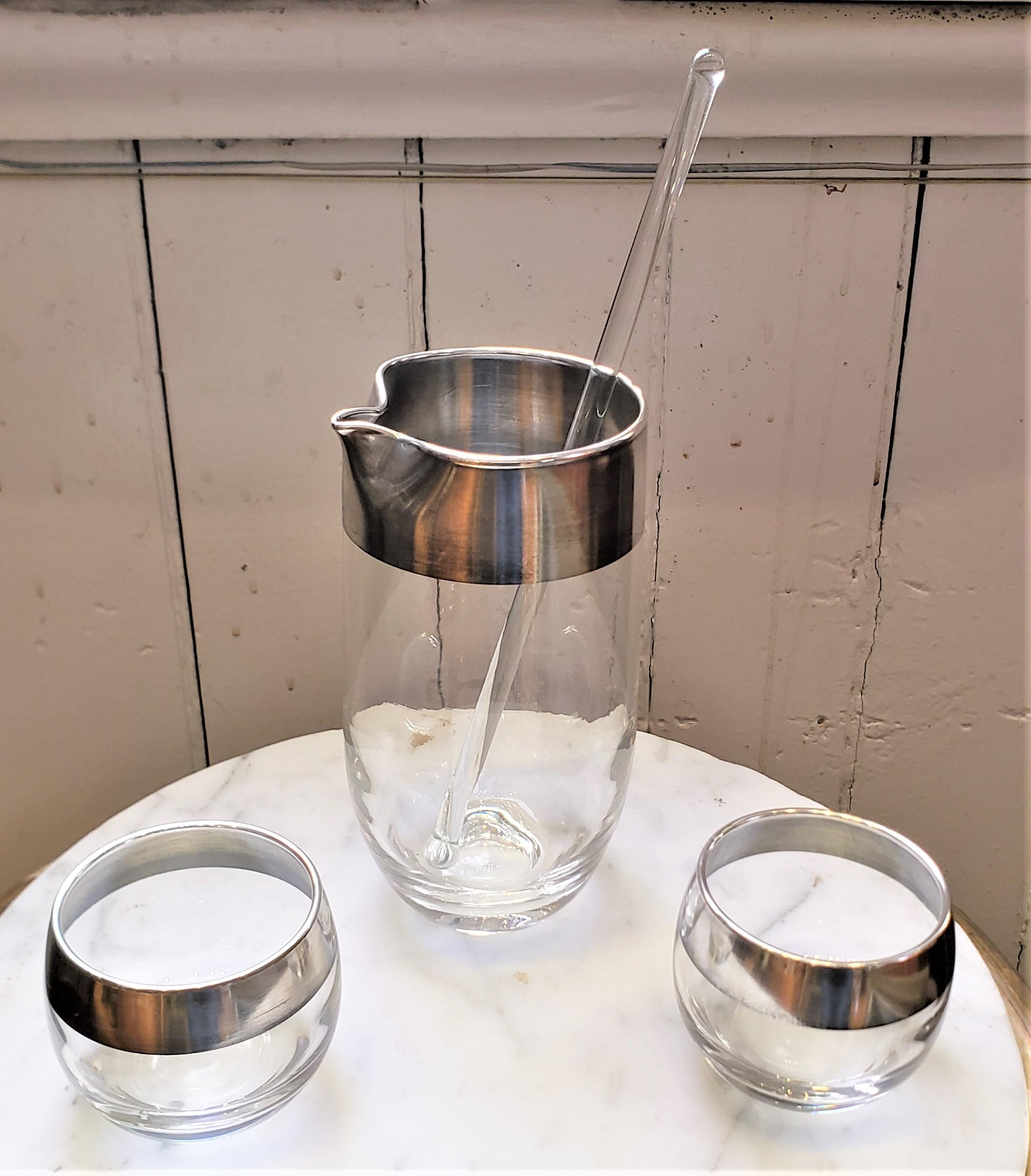 This four piece cocktail pitcher and glass set was done by the well known Dorothy Thorpe of the United States in approximately 1965 in the period Mid-Century style. The set is composed of a cocktail pitcher, glass stir stick, and two of her