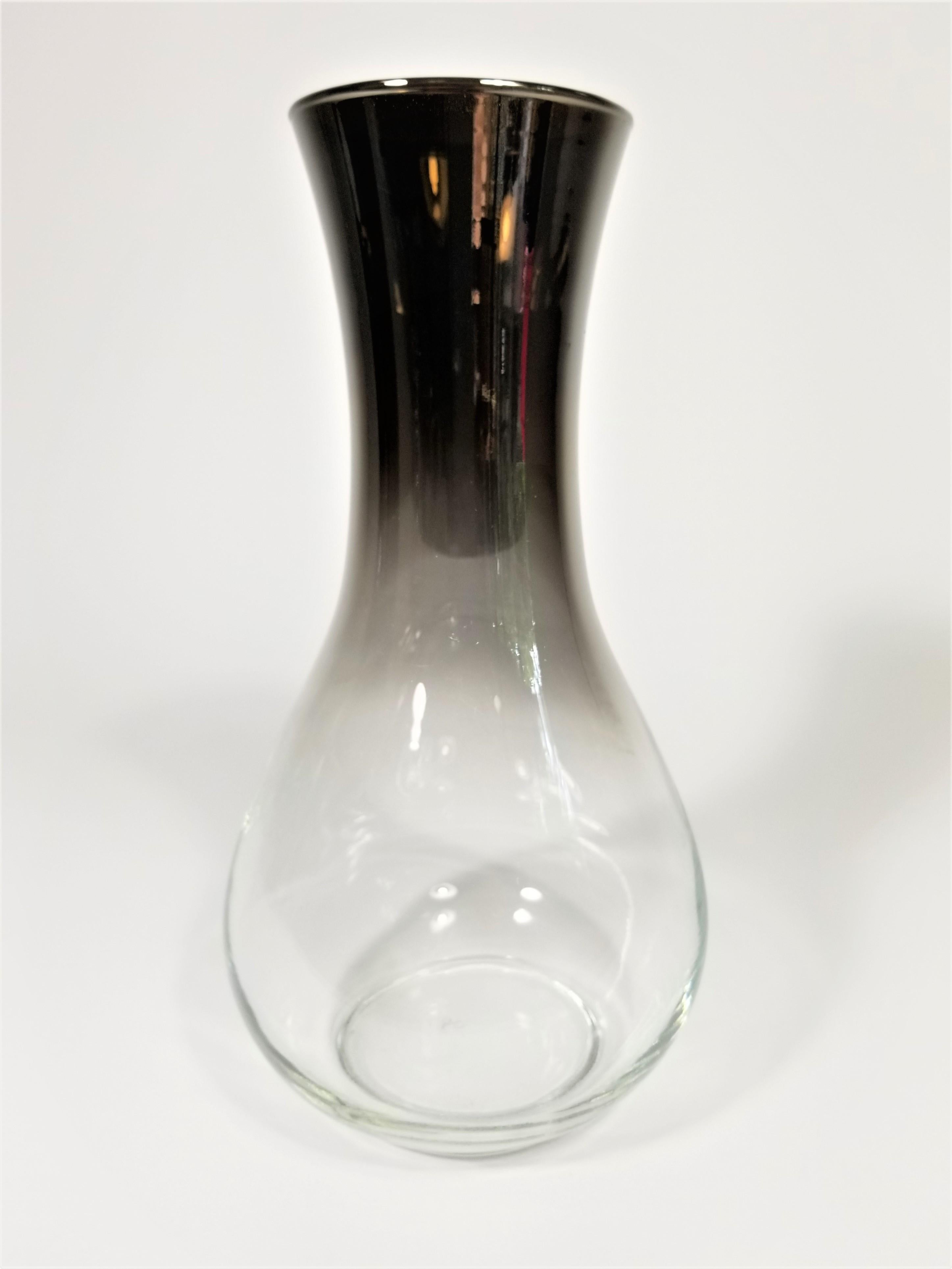 Midcentury Dorothy Thorpe style carafe with silver fade by Libbey glass company. Although originally designed to be a carafe could serve dual purpose as a vase.
Measurements:
Height: 9.5 inches
Diameter at Top: 3.5 inches
Diameter: 5 inches.
 