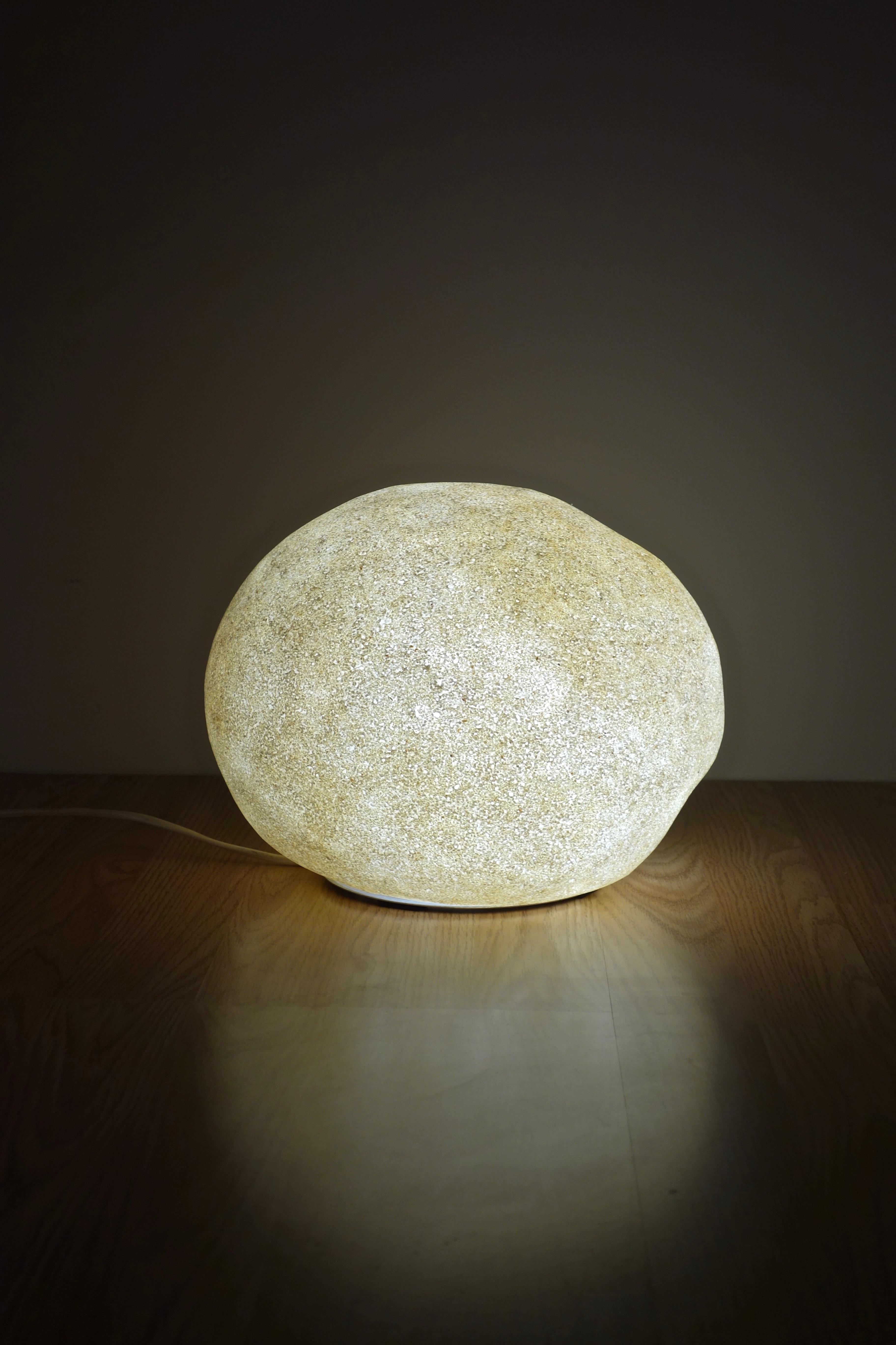 “Dorra” lamp designed by André Cazenave for Atelier A. Arnal

French manufacturing from the 1970s.

This iconic pebble-shaped lamp is made of polyester coated with marble powder spraying.

1st edition with very fine grain.
Circular aluminum base