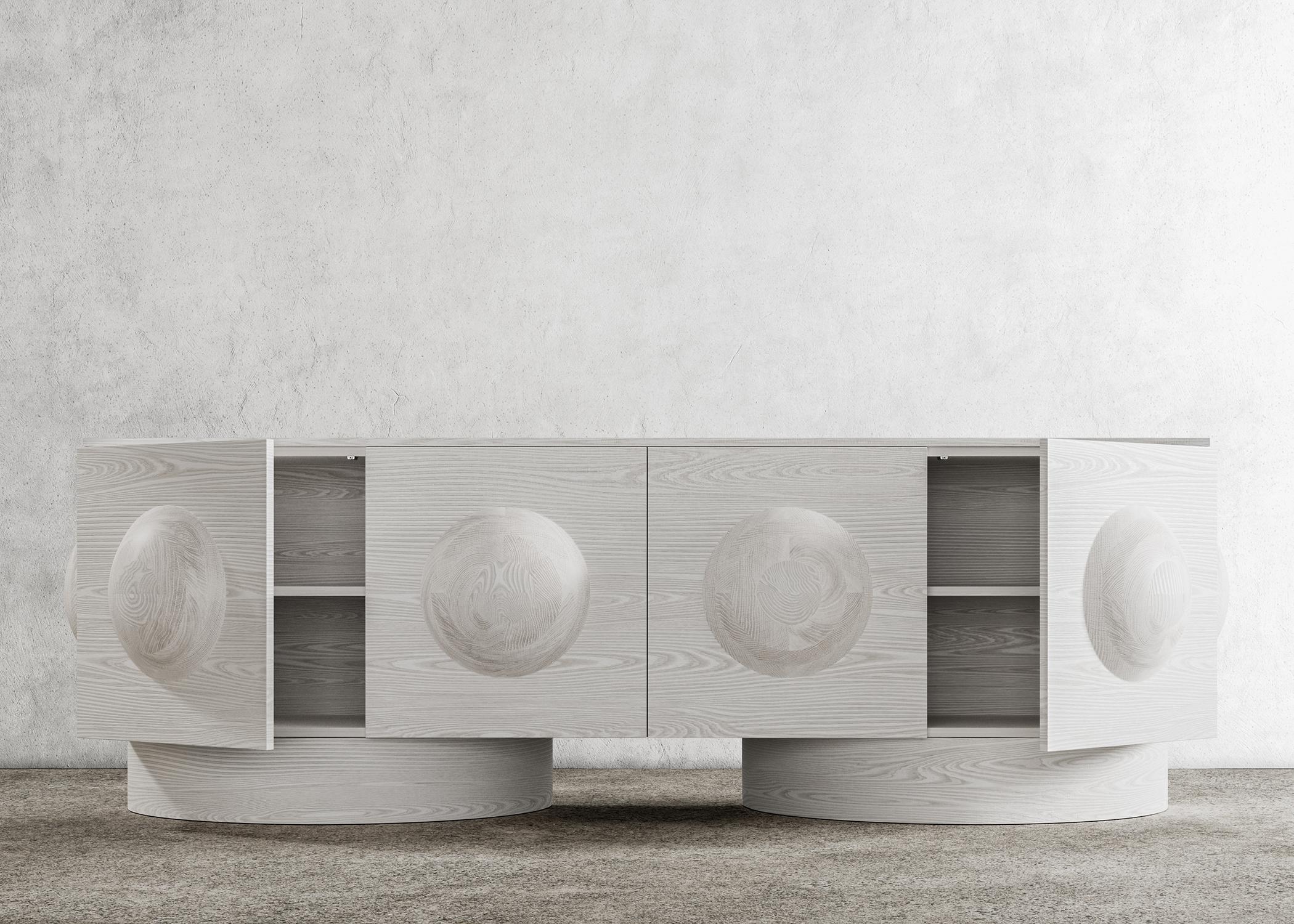 DOT CREDENZA - Modern Bleached White Oak Body and Base

The Dot Credenza is a contemporary piece of furniture with a unique design element - a sculpted wood sphere detail - and wood plinth bases, which give it an architectural feel. This modern