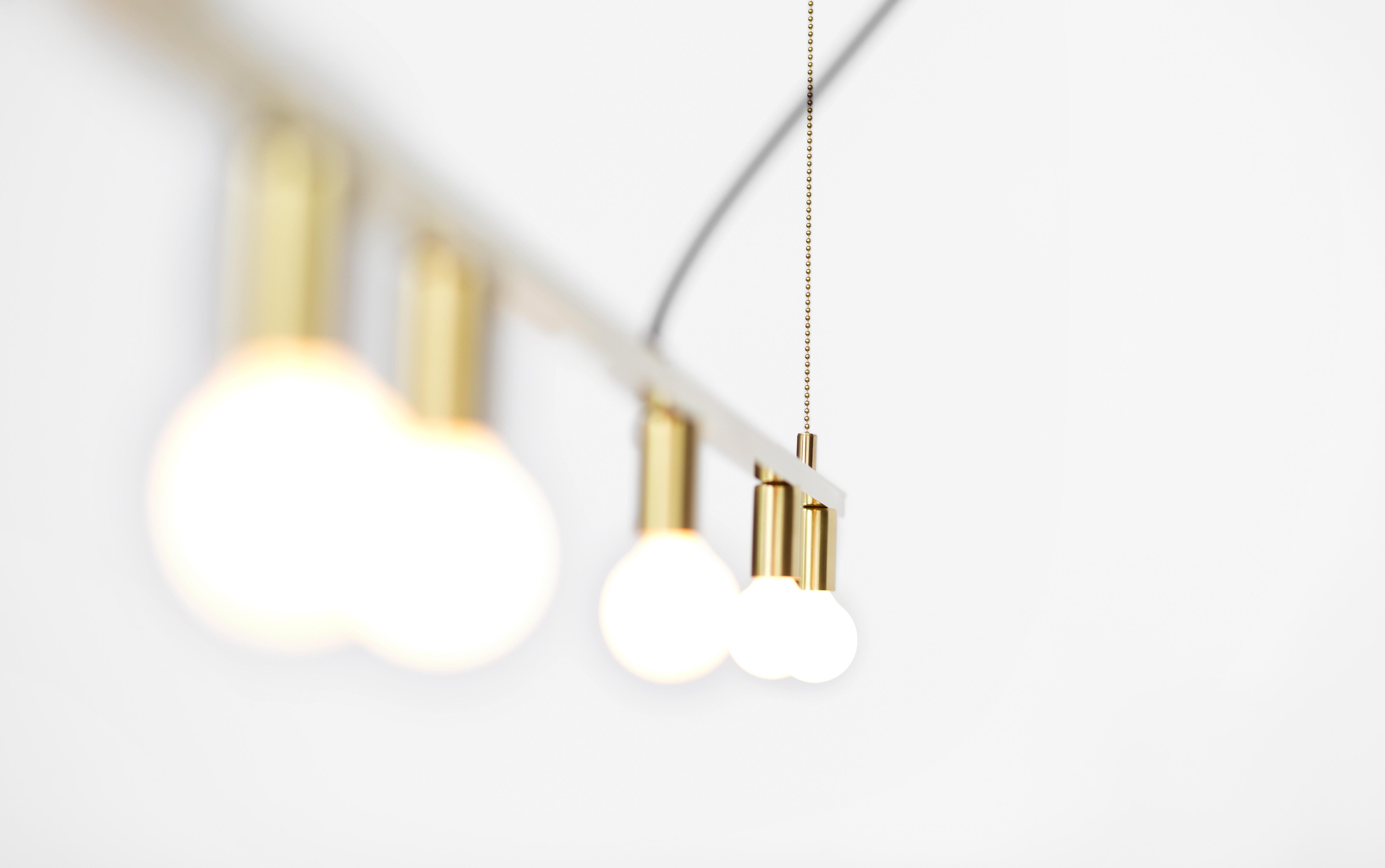 The Dot collection combines the directness of exposed, spherical bulbs with the rich materiality of brass. Focused, geometric compositions contain these two features, balancing line, surface, and luminous points. The result is a collection of lamps