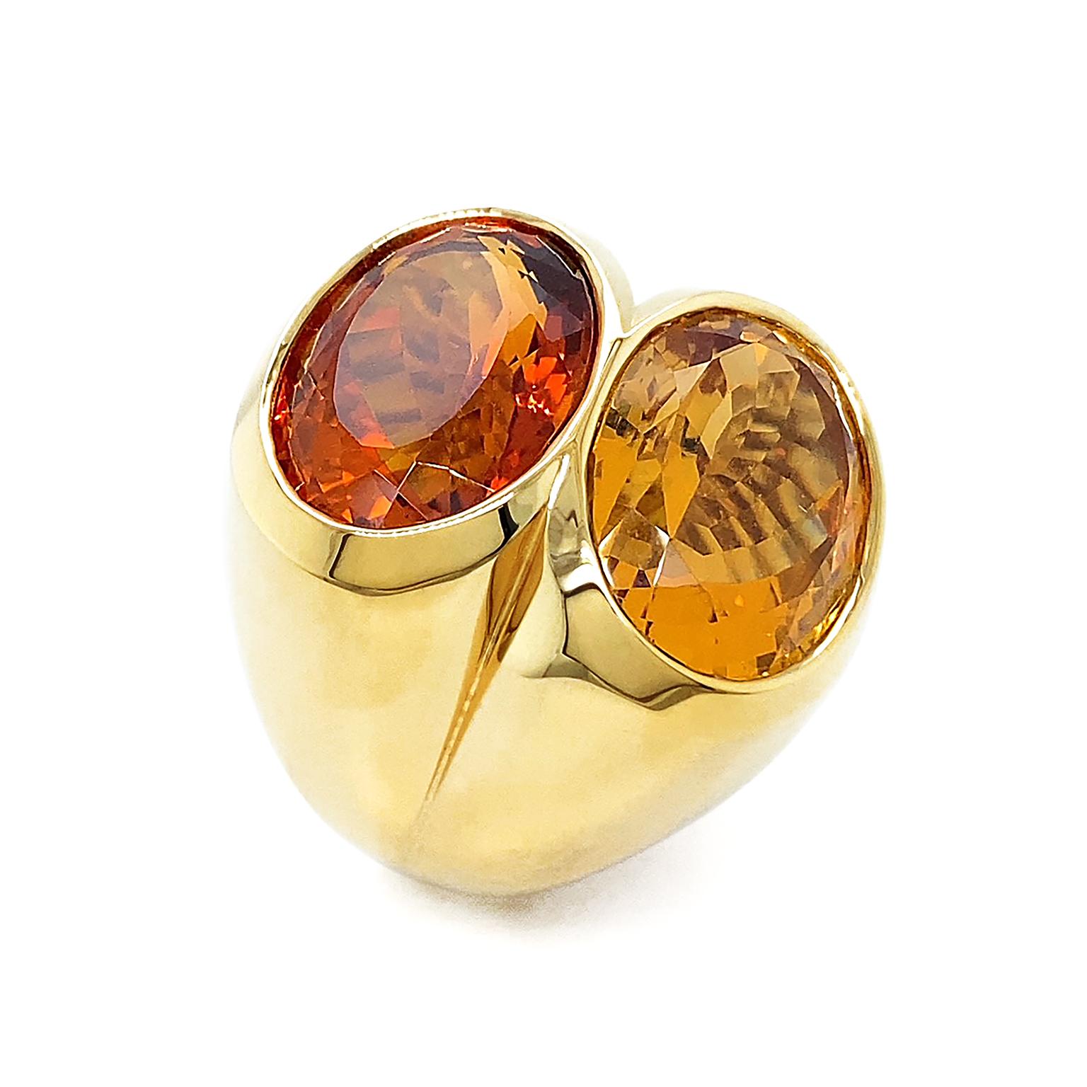 Two citrines unite together to showcase the array of the gemstone. One is a red-orange Madeira citrine, while the the other is yellow-orange. The two oval citrines are bezel set in an 18k yellow gold double shank for a blazing appraisal. The