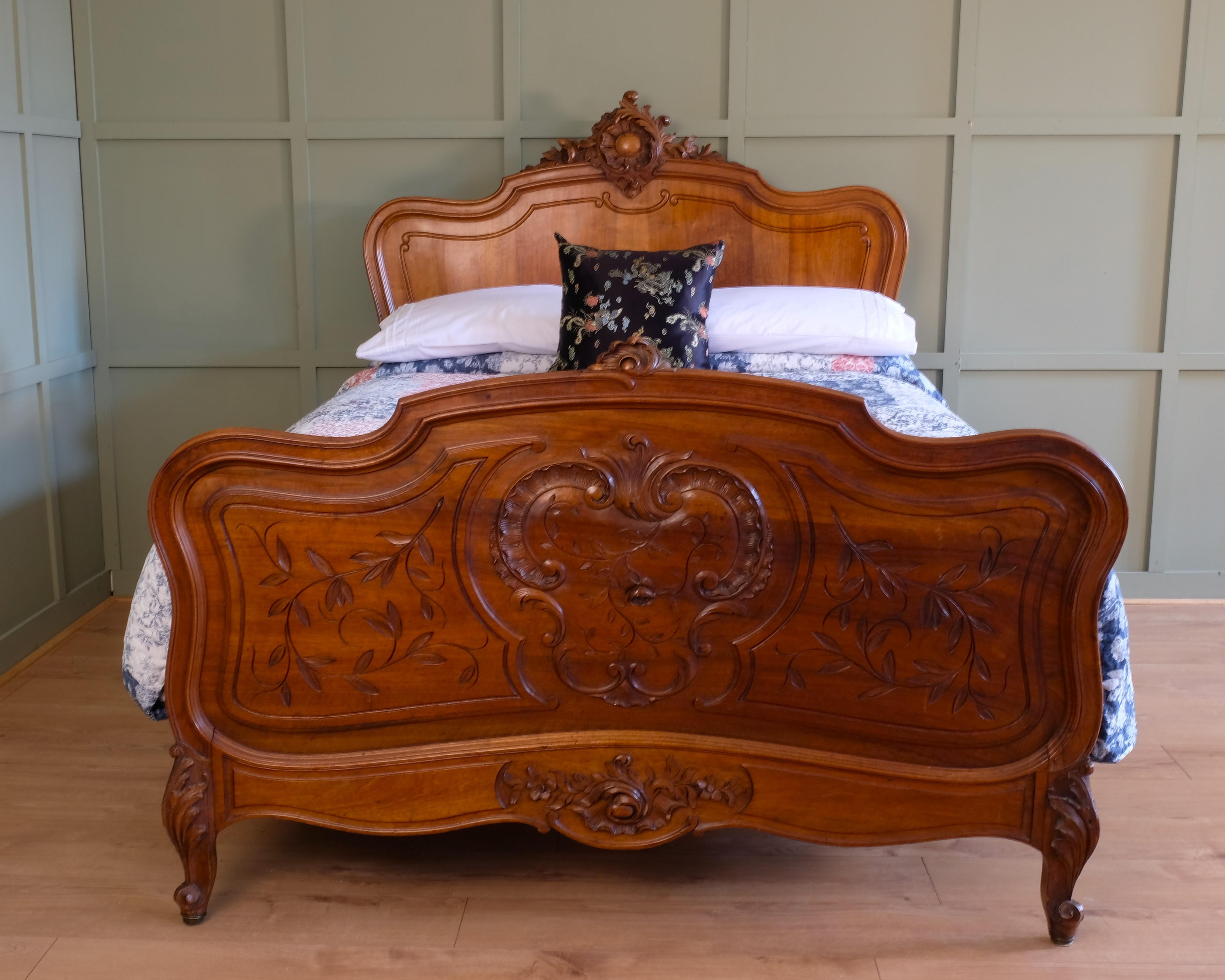 Double (4’6) antique French walnut Louis xv bedstead. This is a very pretty example, with beautiful carved flowers and leaves on the head and foot end. The legs are also decorative. The frame is solid walnut and not veneered and has a lovely golden