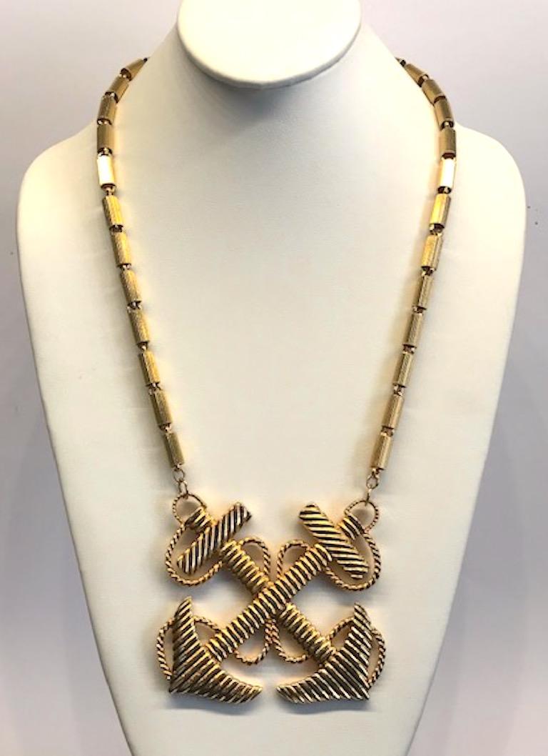 Nautical these of crossed anchors with twisted rope pendant necklace from the 1970s. The chain is a ribbed tube link with each 0.25 of an inch in diameter and 0.5 of an inch long. The pendant measures 3.25 inches wide and 3 inches high. End to end