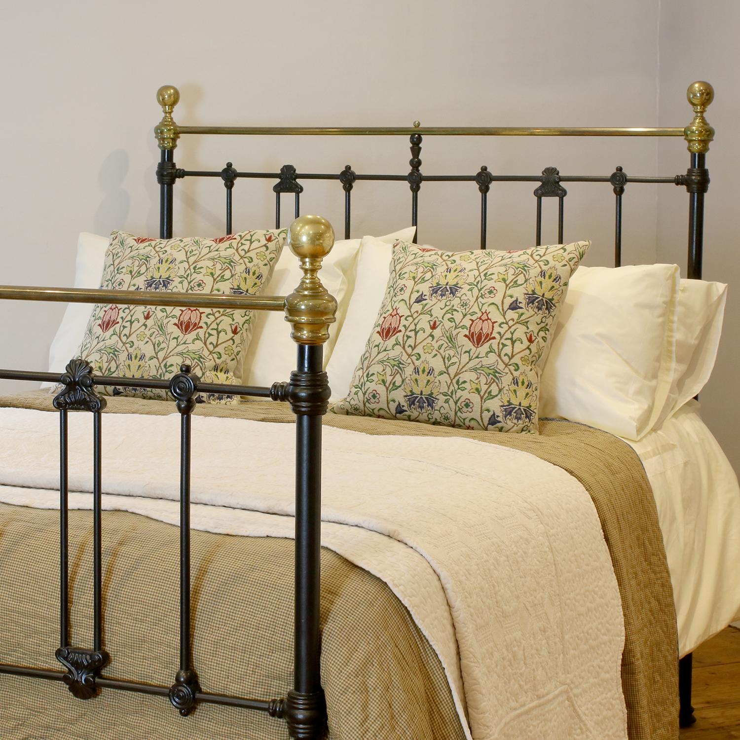 Late Victorian antique brass and iron bed with decorative cast iron mouldings, finished in black, with straight brass top rail and round knobs. 

This bed accepts a double size 4ft 6in wide (54 inch or 135cm) base and mattress.

The price