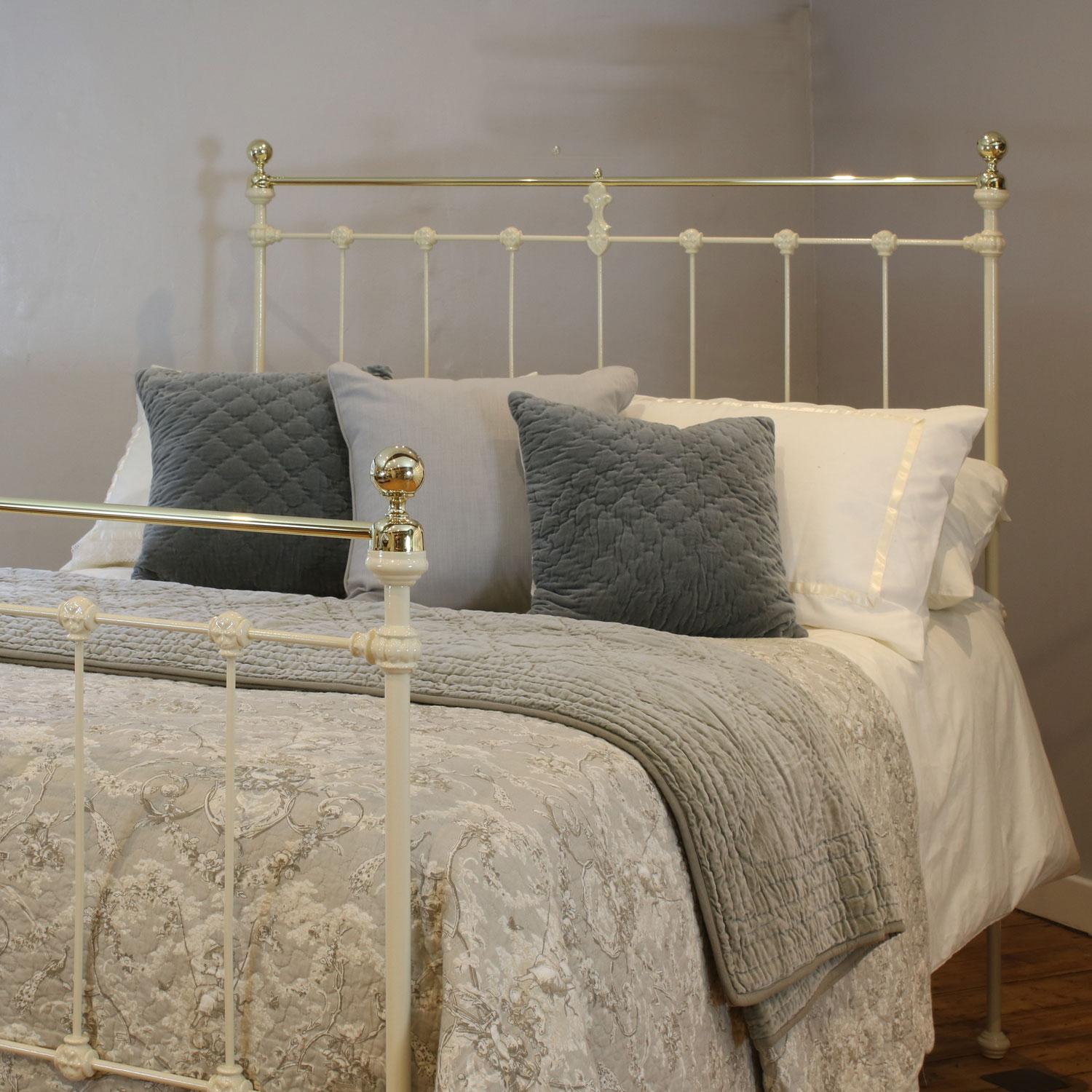 Late Victorian antique brass and iron bed with decorative cast iron mouldings, finished in cream, with straight brass top rail and round knobs. 

This bed accepts a double size 4ft 6in wide (54 inch or 135cm) base and mattress.

The price