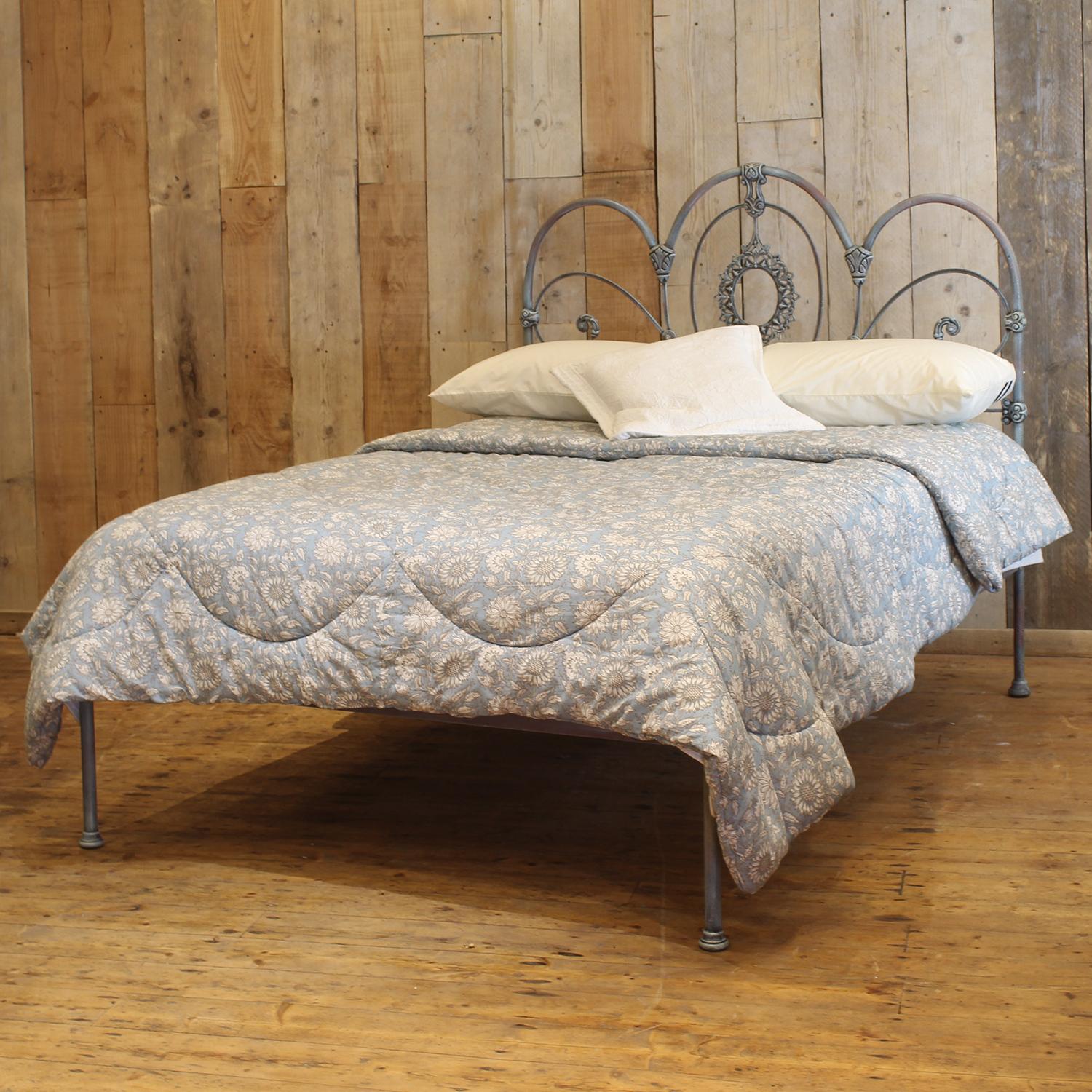 A Mid-Victorian antique brass and iron bed finished in hand paint blue verdigris, with decorative castings and three arch design. This bed has a low foot board, suitable for a smaller room.

This bed accepts a double size 4ft 6in wide (54 inch or