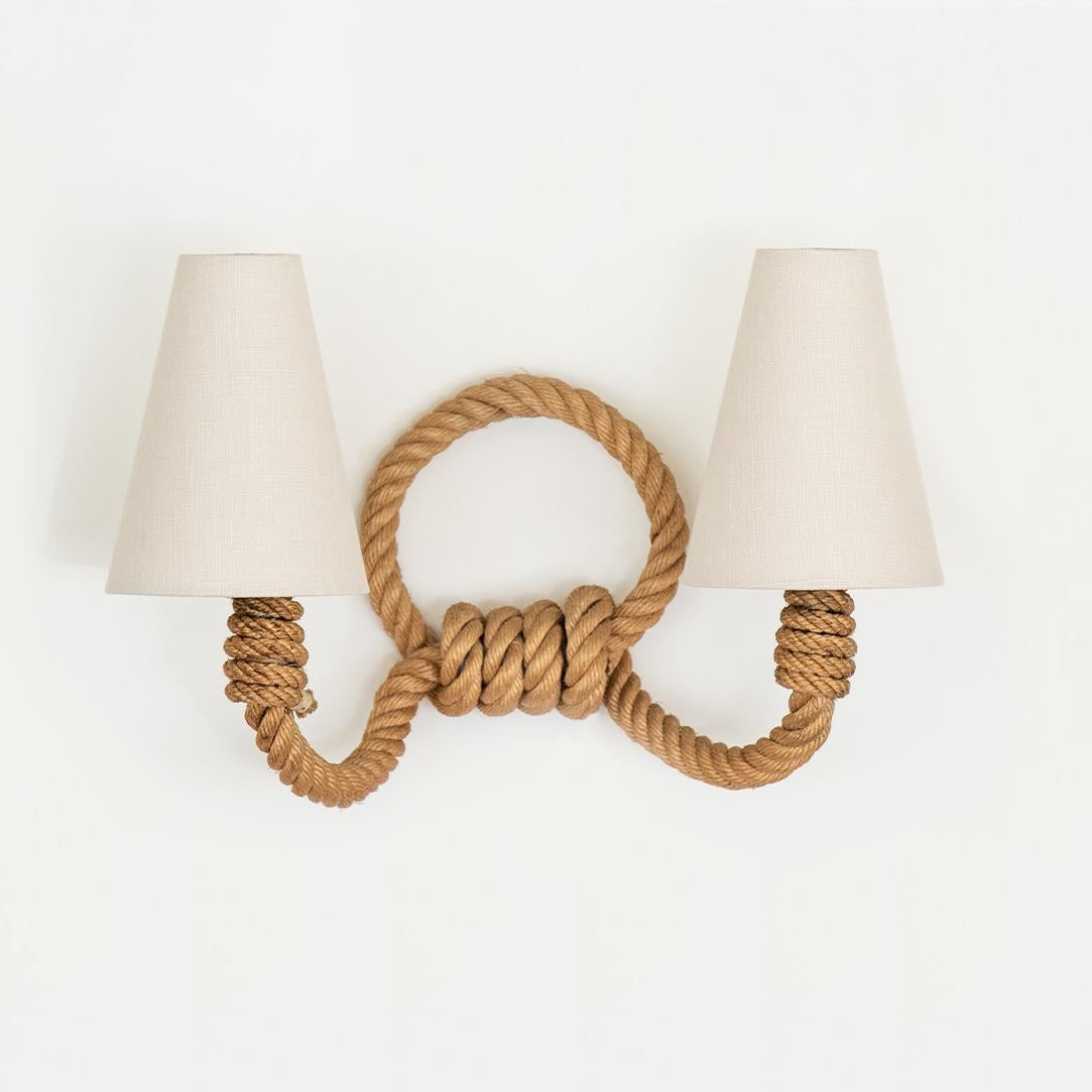 Vintage rope sconce by Audoux-Minet from France, 1950's. Brown twisted rope with two curved rope arms each with a single socket. New clip on oyster white linen shades. Newly re-wired with brown cloth twist cord, switch, and hand plug for wall.