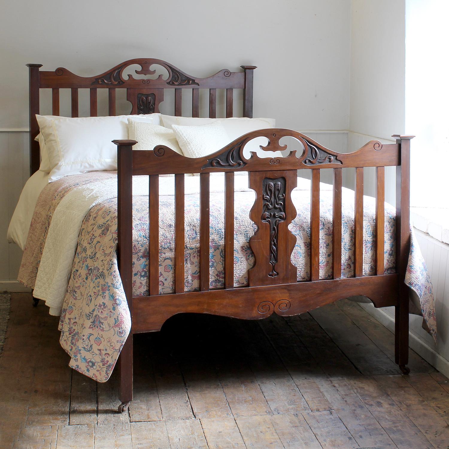 A fine double antique bed from in the Art Nouveau style from the north of England, circa 1910, with slatted panels, carved features and pagoda caps.

This bed accepts a double 54