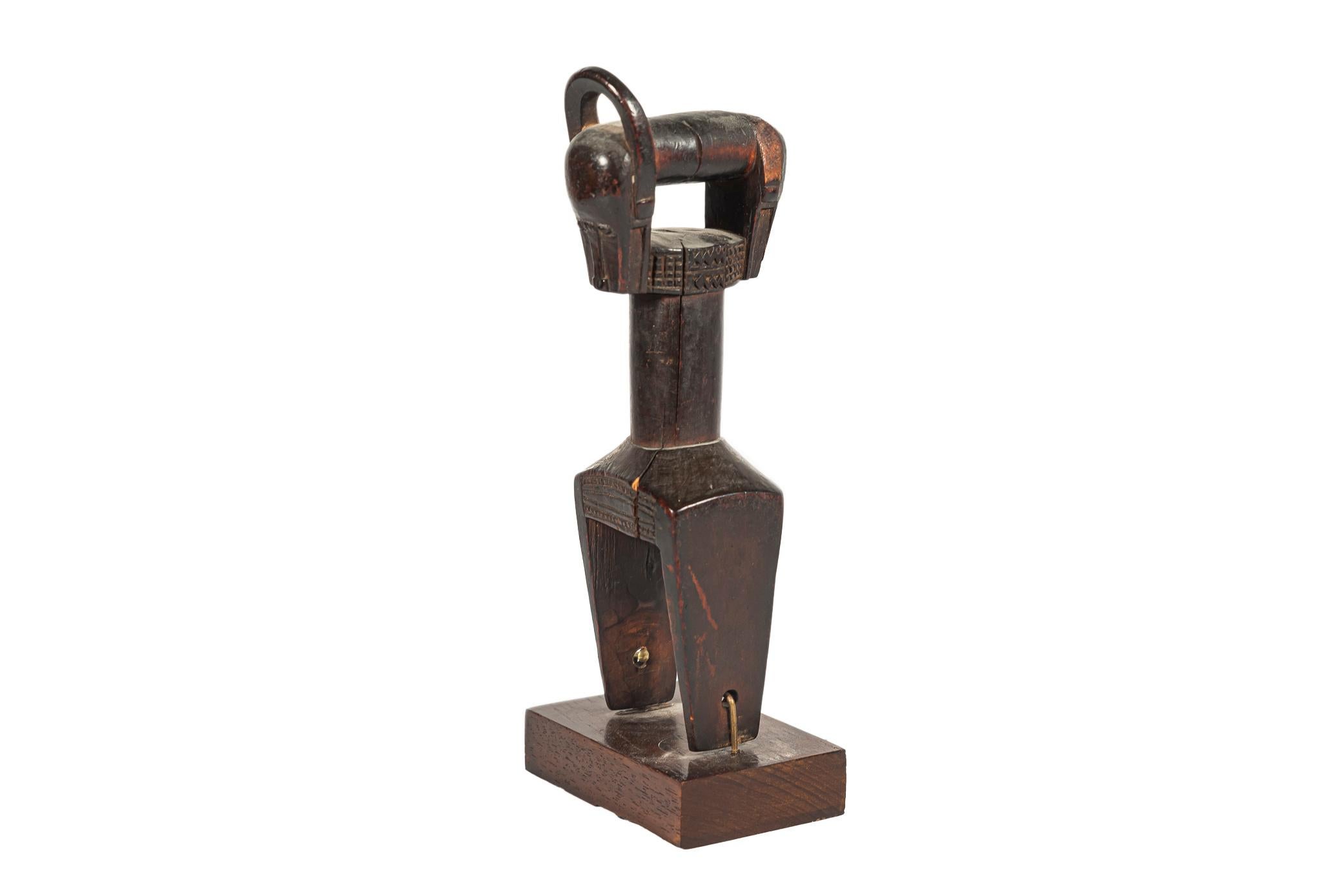 Double Baoule weaving pulley, 
Brown patina wood,
Two Janus heads,
Horn missing on one head,
Ivory Coast, early 20th century.

Measures: Height 20 cm, depth 8 cm, width 6 cm.

In Côte d'Ivoire, the most ordinary objects a priori had to meet
