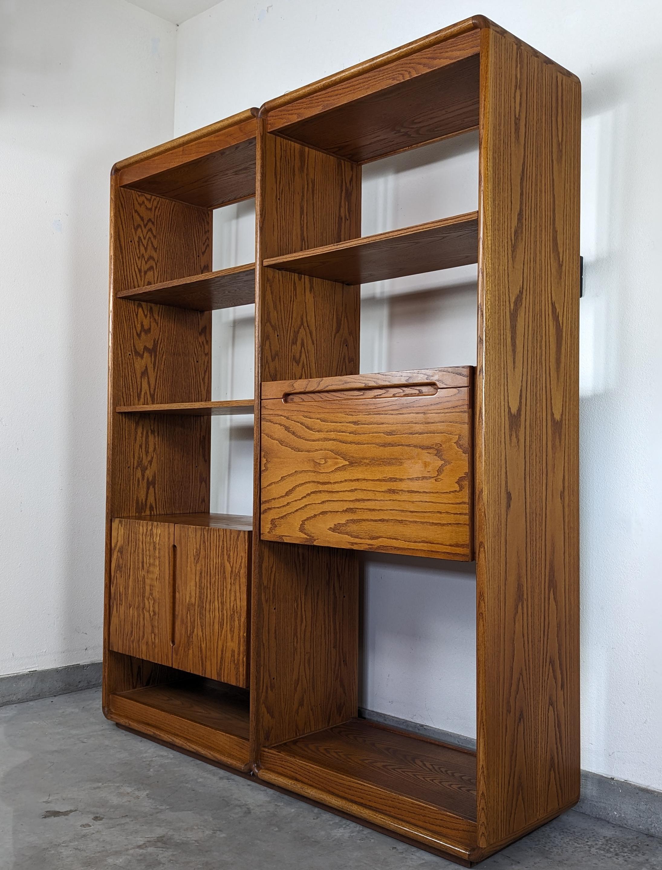 This exceptional vintage freestanding wall unit shelving system, designed by the renowned Lou Hodges for California Design Group in the 1970s, exemplifies the best of mid-century modern craftsmanship and design aesthetics. Constructed with a warm