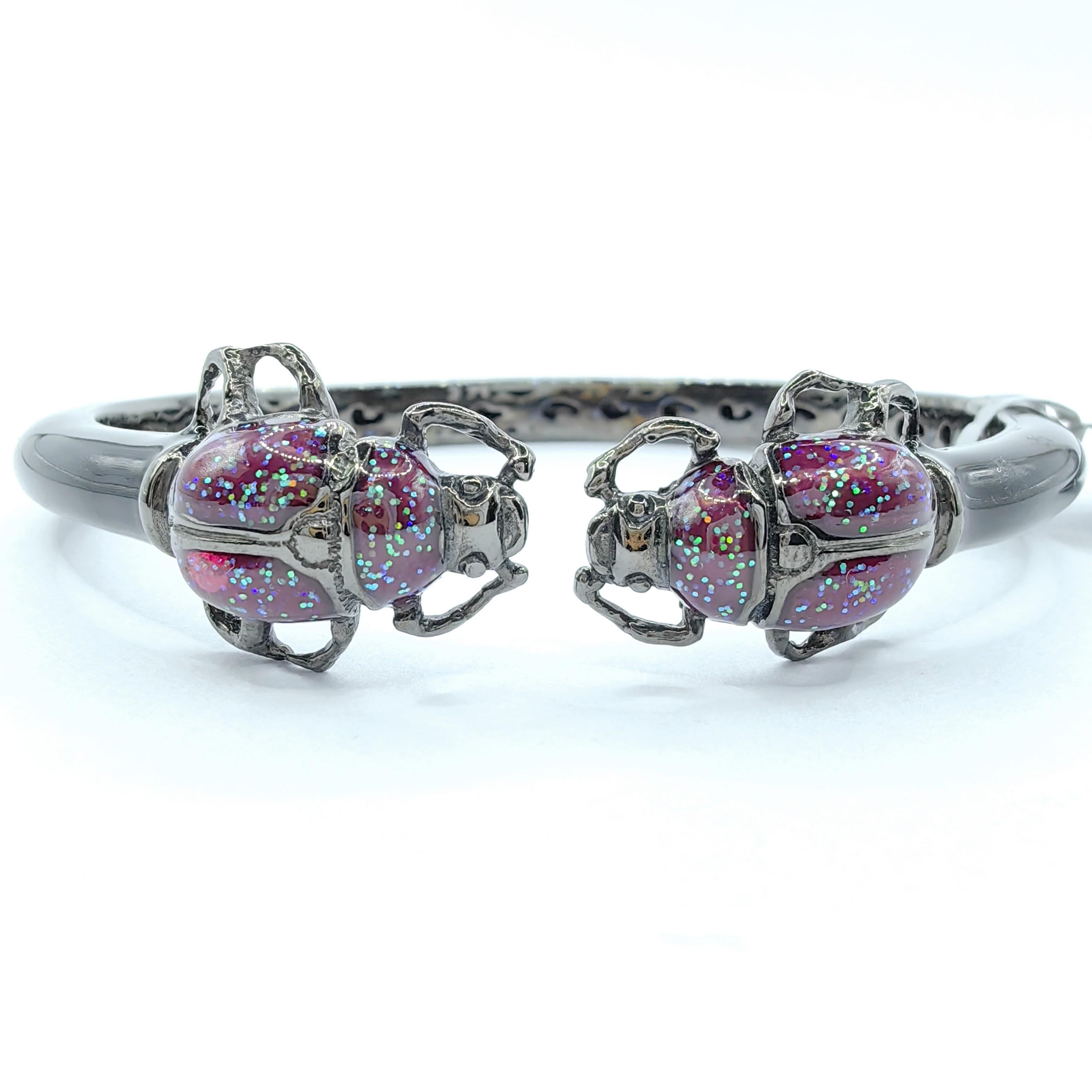 Tauchen Sie ein in die skurrile Welt der von der Natur inspirierten Eleganz mit dem Double Beetle Purple Glitter Enamel Sterling Silver Open Cuff Bracelet. Dieses auffällige Armband zeichnet sich durch zwei kunstvoll gearbeitete Käfermotive aus, die
