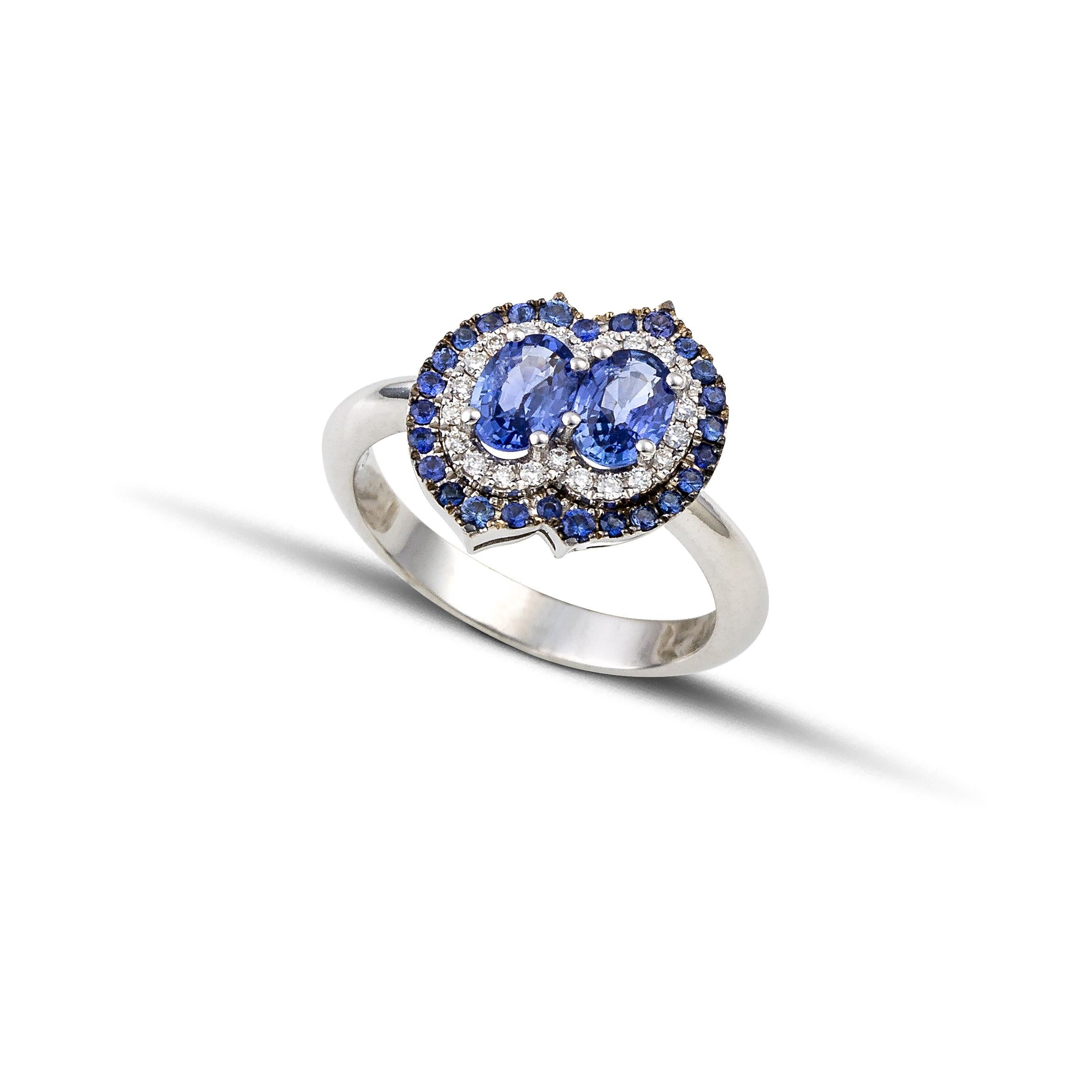 Beautiful ring in 18Kt white gold with  two blue color  sapphires in marquise cut in a very different and exquisite double setting with diamonds  and sapphires brilliant cut around the center of the ring.
The ring has a channel setting and the