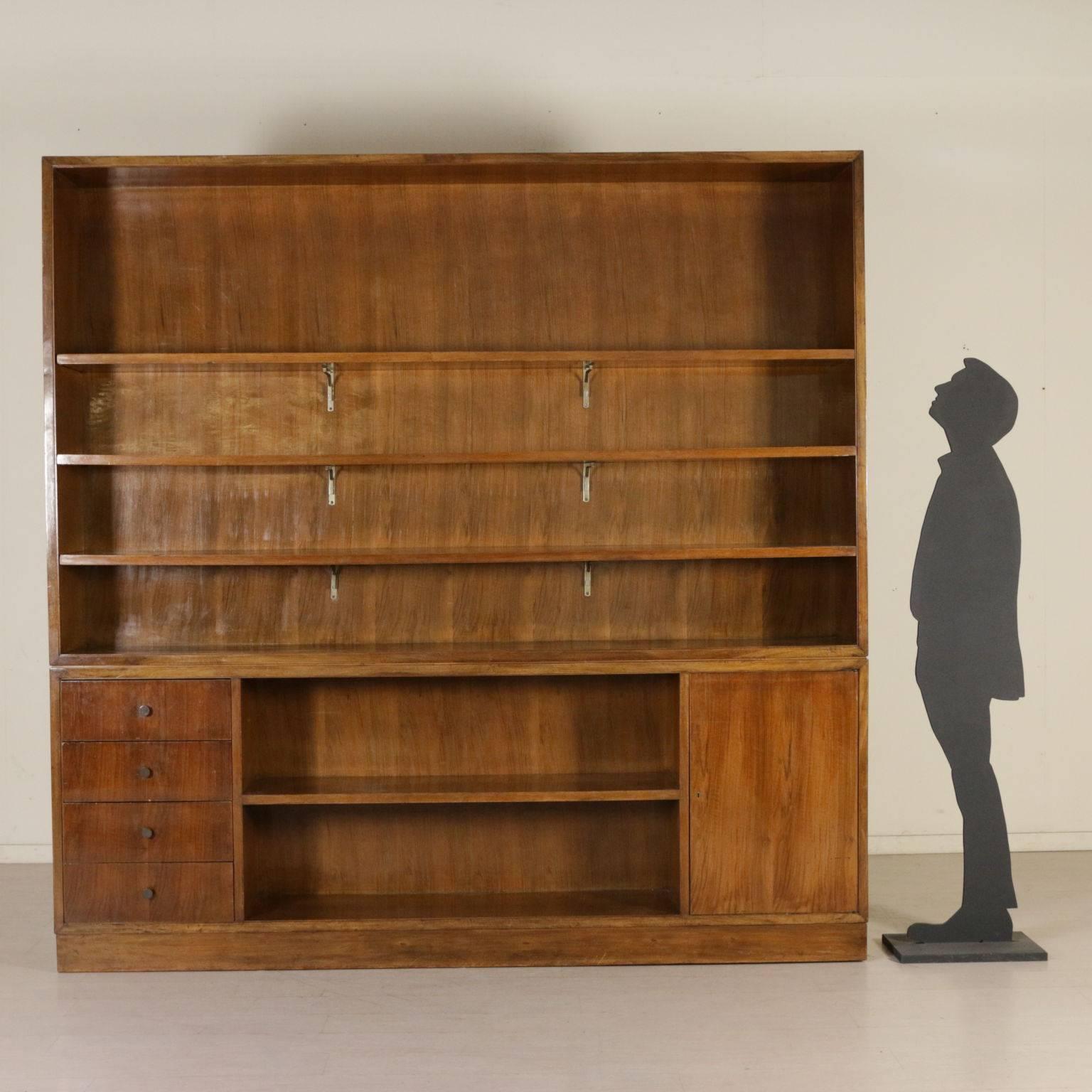 A double body bookcase, basement with a storage unit and removable top, open shelves in the upper part. Walnut veneer. Manufactured in Italy, 1940s.