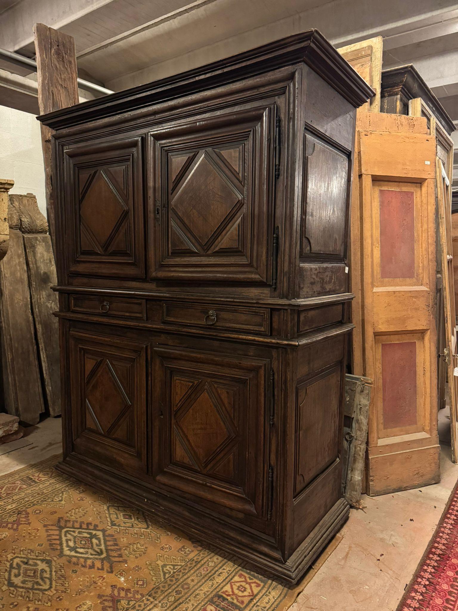 Antiguo mueble de doble cuerpo, aparador con cuatro puertas talladas con estantes en el interior y dos cajones centrales, en madera de nogal preciosamente tallada con rombos fresados, original del siglo XVII, procedente del Piamonte en Italia.
Tiene