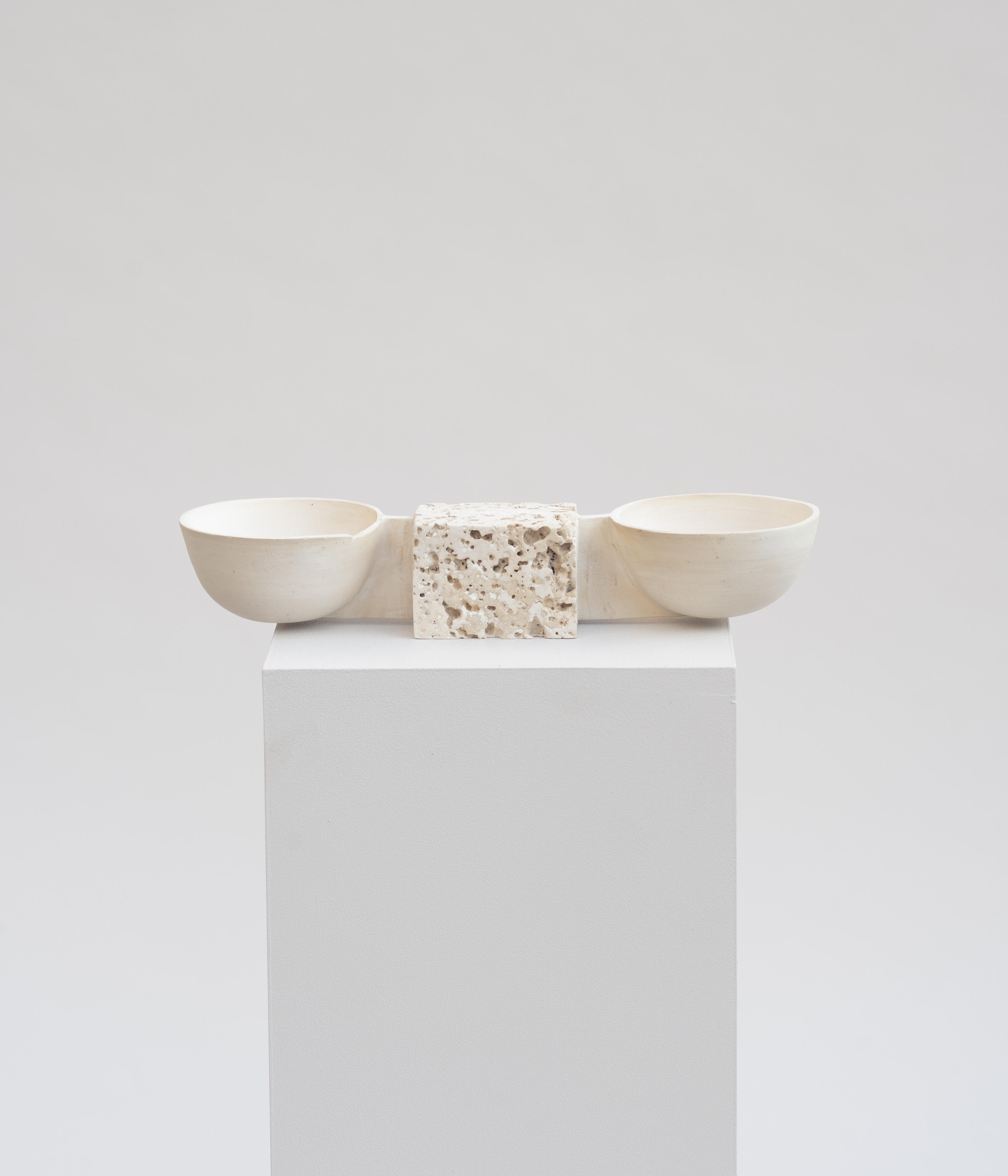 Double bowl by Turbina.
Future Archeology.
Dimensions: H 4.5 x W 24 x D 8 cm.
 Bowl Diameter 8 cm.
Materials: Natural / White Mayolica Fired Clay, Stone Cast.

Future Archeology: The Object as connection and symbol to understand past and future