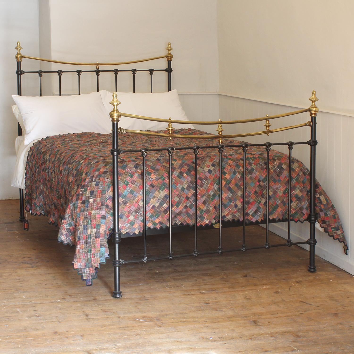 A Victorian brass and cast iron bedstead finished in black with curved brass top rails and decorative castings.

This bed accepts a double size 4ft 6in wide (54 inch or 135cm) base and mattress. 

The price includes a firm standard bed base to