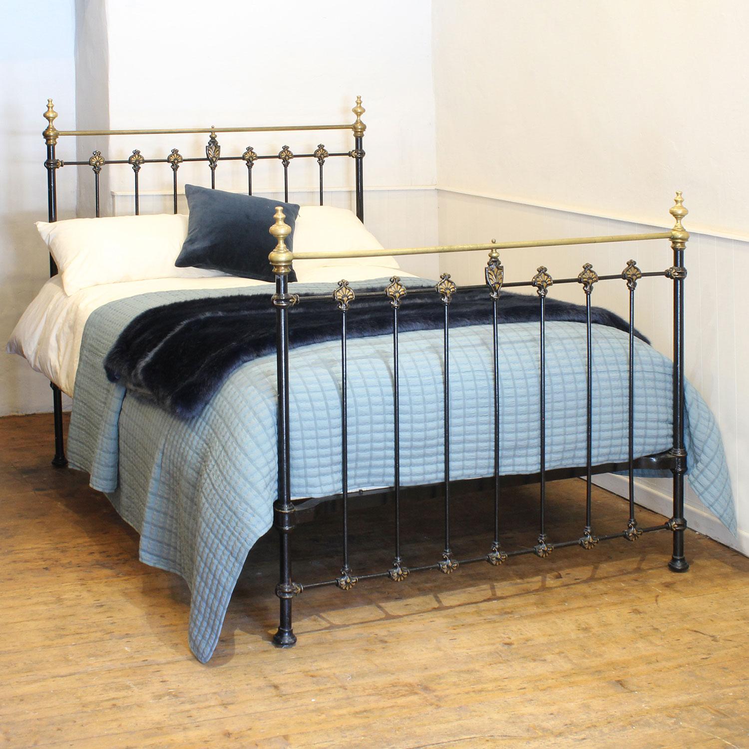 A cast iron and brass antique bed, finished in black and hand painted gold lining on the castings. The straight brass top rail has naturally tarnished as have the decorative brass knobs. The brass could be repolished if required.

This bed accepts