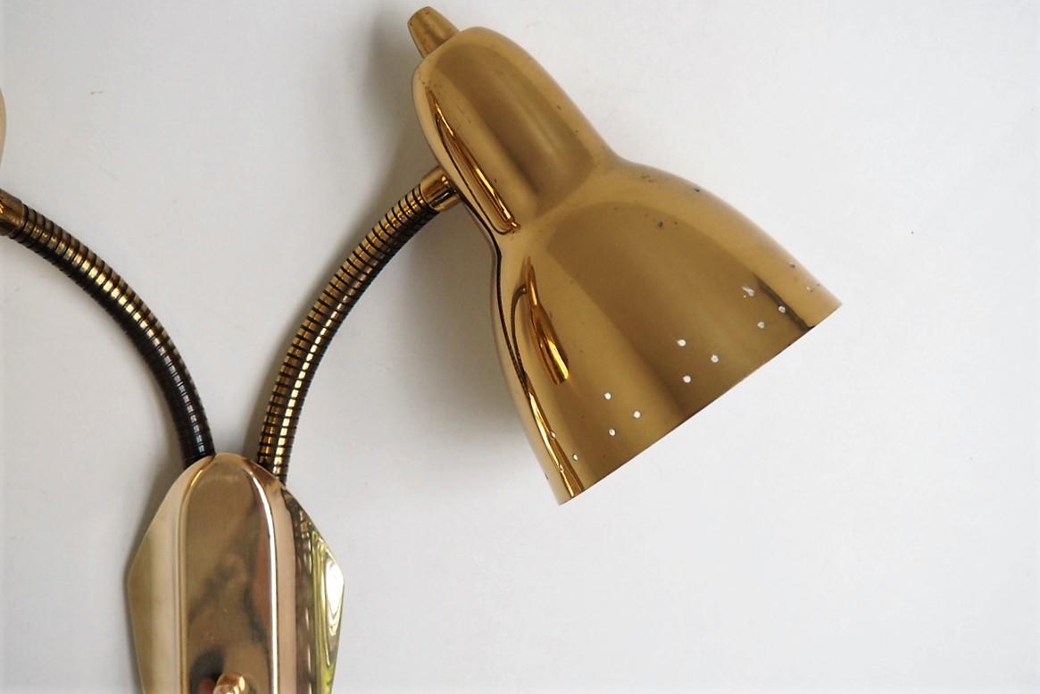 Double brass sconces with decorative hole pattern and flexible arms in solid brass made in Paavo Tynell style, Scandinavian vintage design from the 1950s - 1960s.

The brass expression of the shades are very beautiful and appears almost as gold.