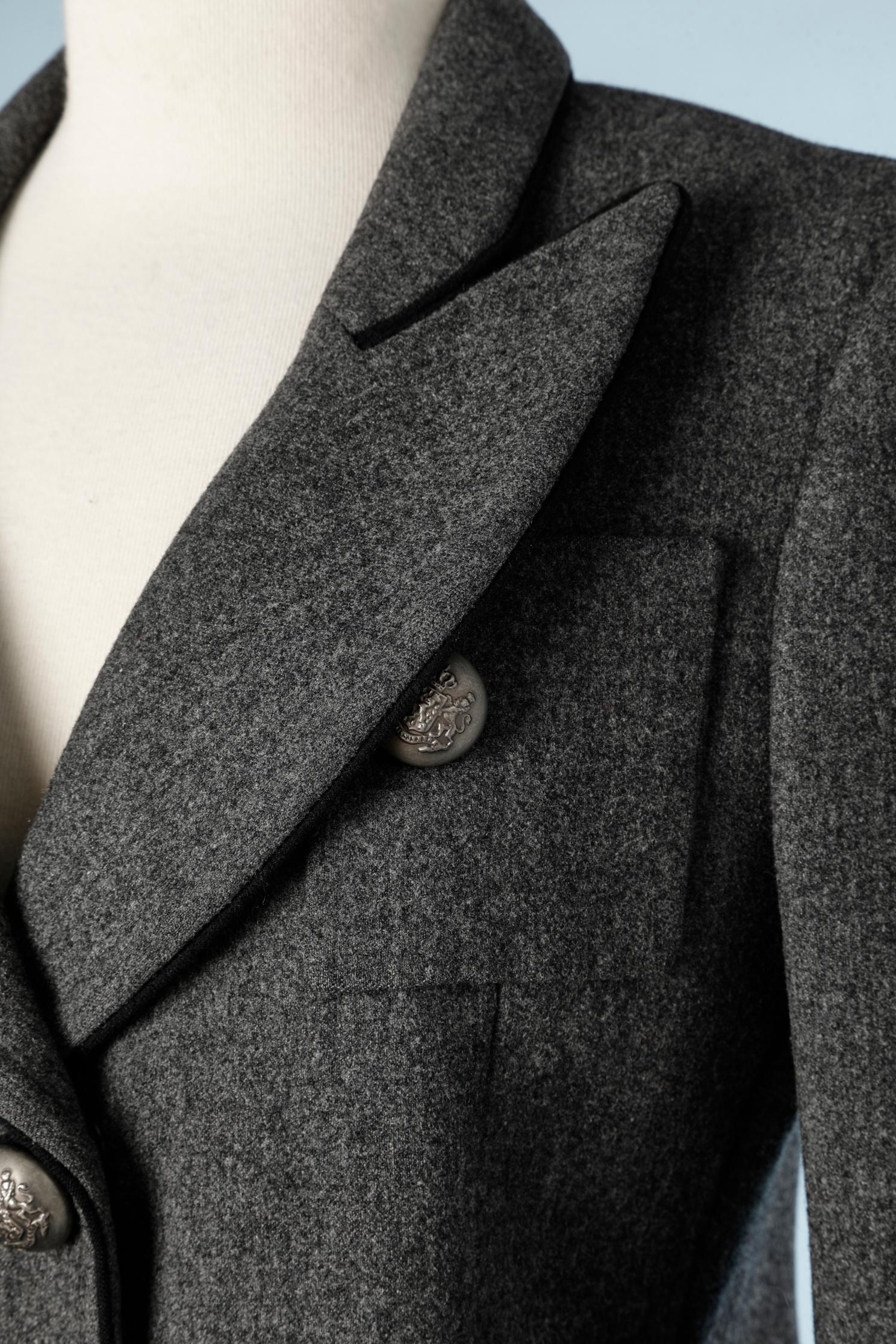 Double breasted grey wool blazer with seal buttons in aged metal. The blazer is close with snap , the buttons are just an embellishment .