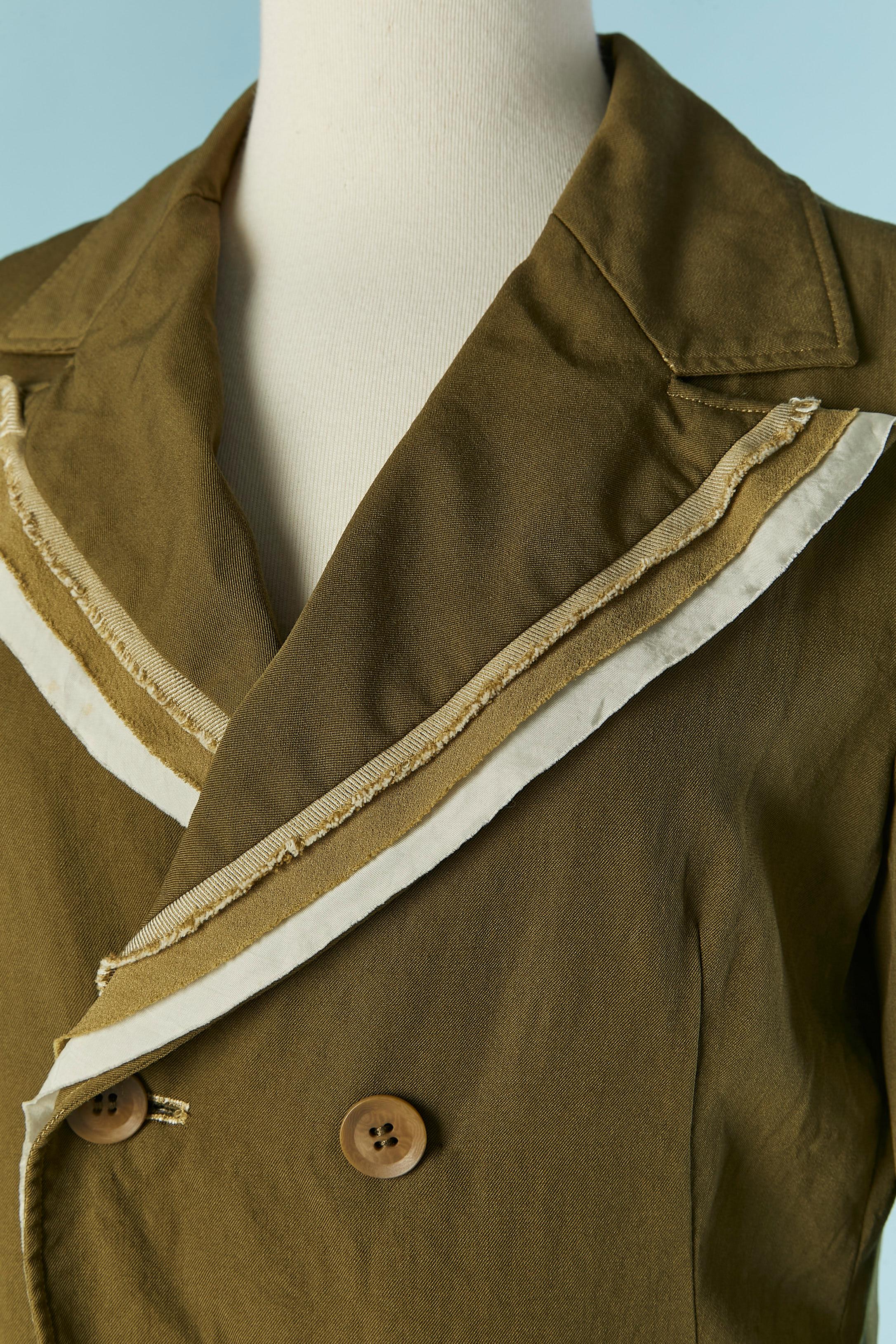 Zweireihige Jacke aus Seide und Cupro mit rauer Schnittkante. Zusammensetzung des Stoffes: 55% Seide, 45% Baumwolle. Tasche auf beiden Seiten. Knopf- und Knopflochverschluss in der vorderen Mitte und ein Druckknopfverschluss innen. Knöpfe auch an