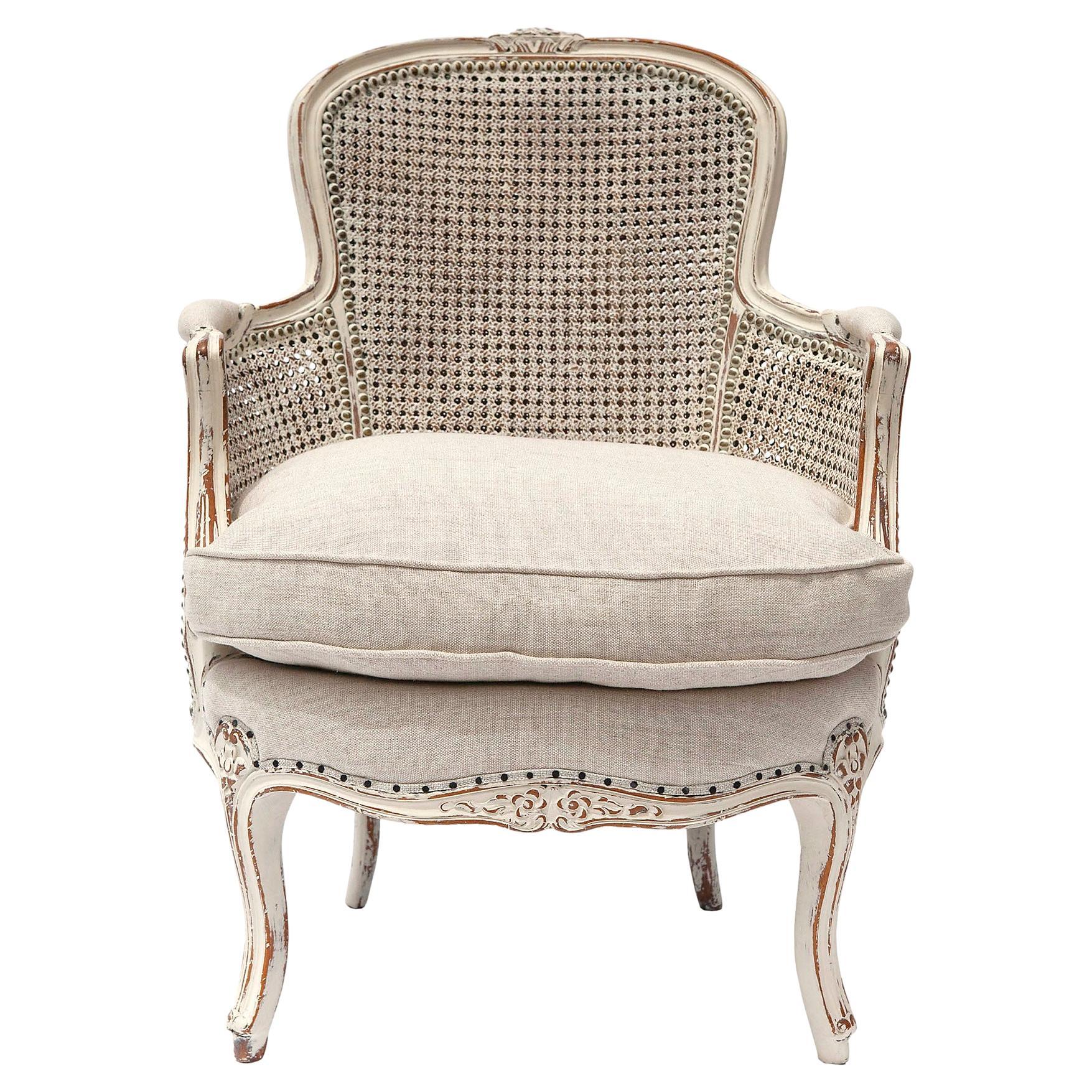 Antique carved Louis XV style armchair with double caned back and side panels. 
Floral rosettes at the crest bottom apron & legs. 
Italian linen blend down/feather cushion.
 