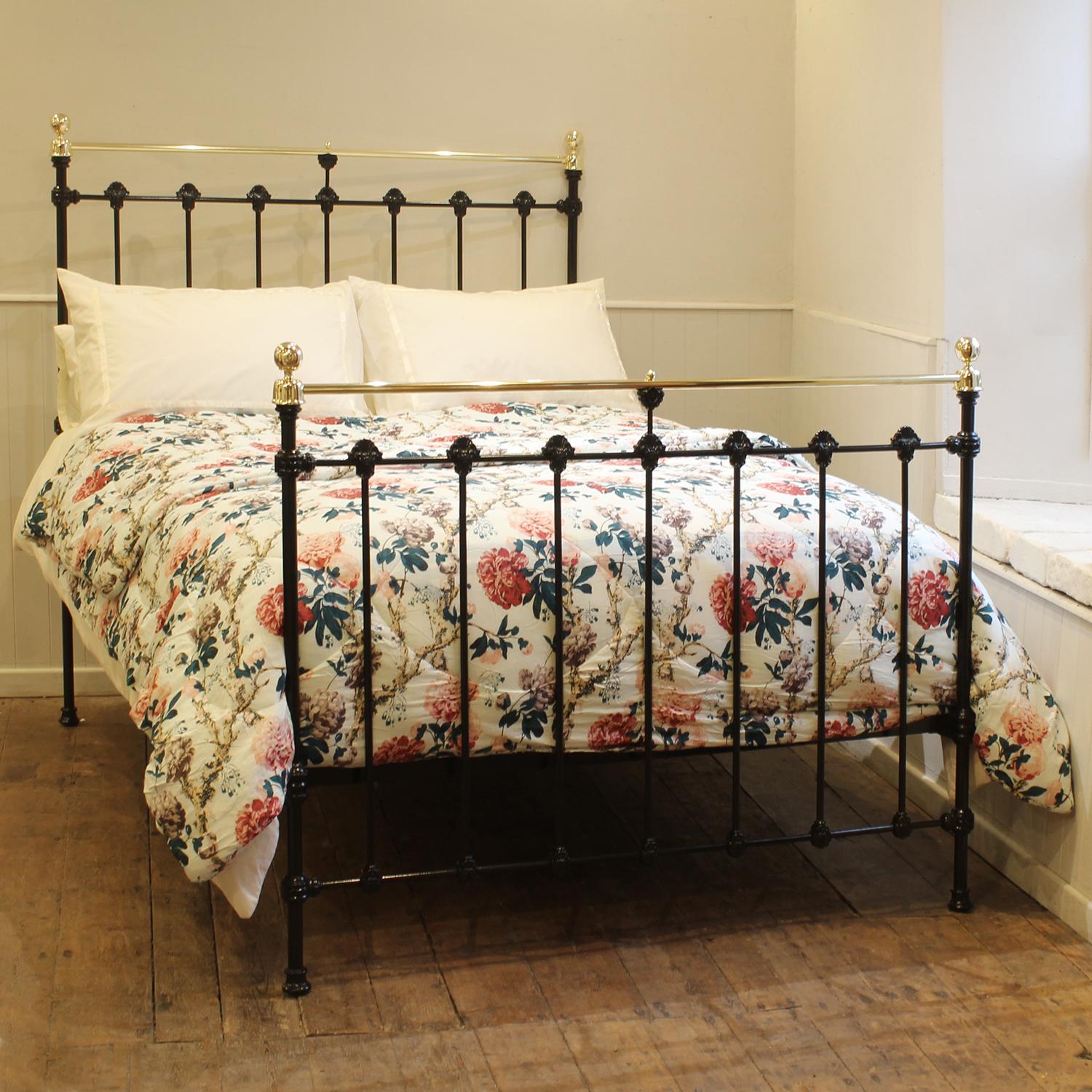 A late Victorian brass and iron bedstead finished in black with straight brass top rails, cap collars, spherical brass knobs and decorative castings.

This bed accepts a double size 4ft 6in wide (54 inch or 135cm) base and mattress.

The price